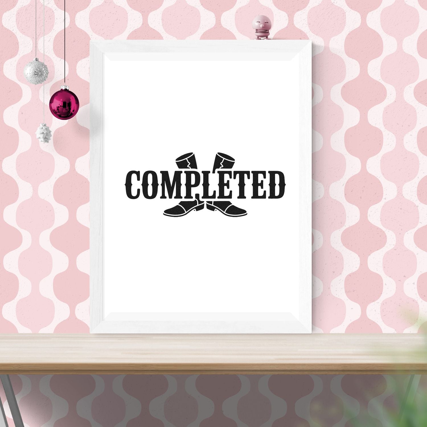 White framed stamp and seal design with black COMPLETED text and boot graphic on a pink patterned wall.