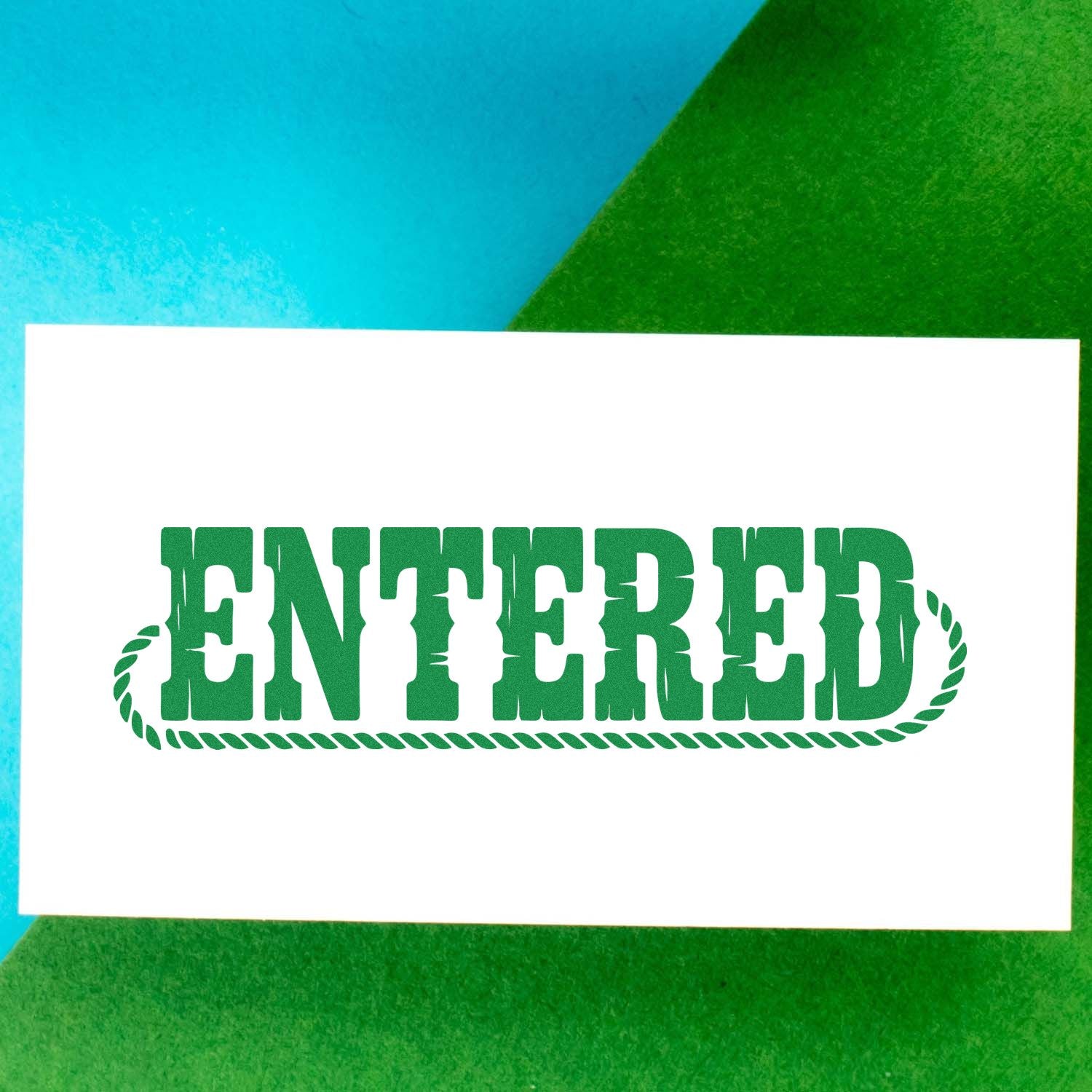 Green ENTERED stamp seal on white card, with rope border, against a blue and green background.