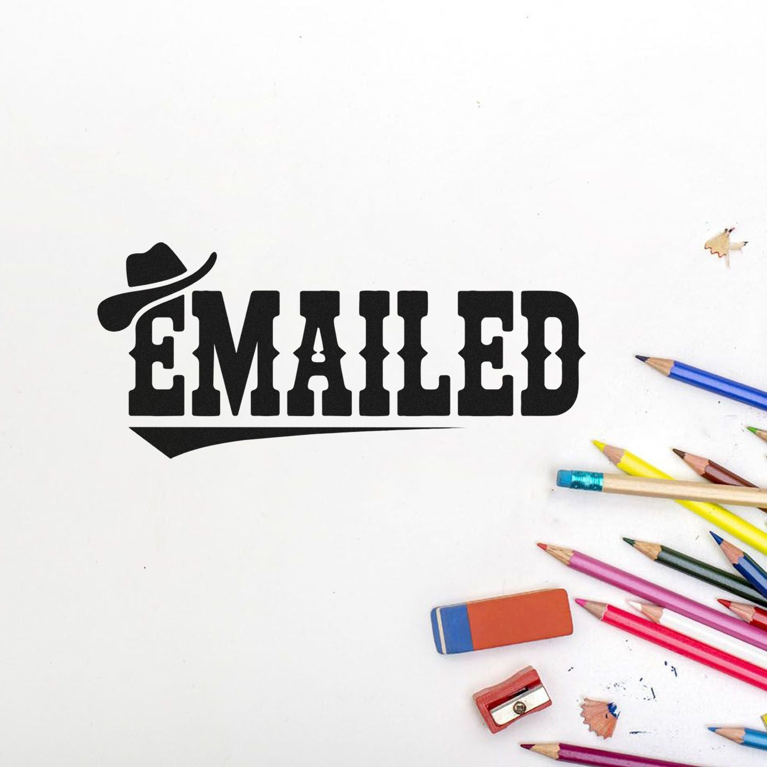 Black EMAILED stamp seal on white paper with colorful pencils, eraser, and pencil sharpener.