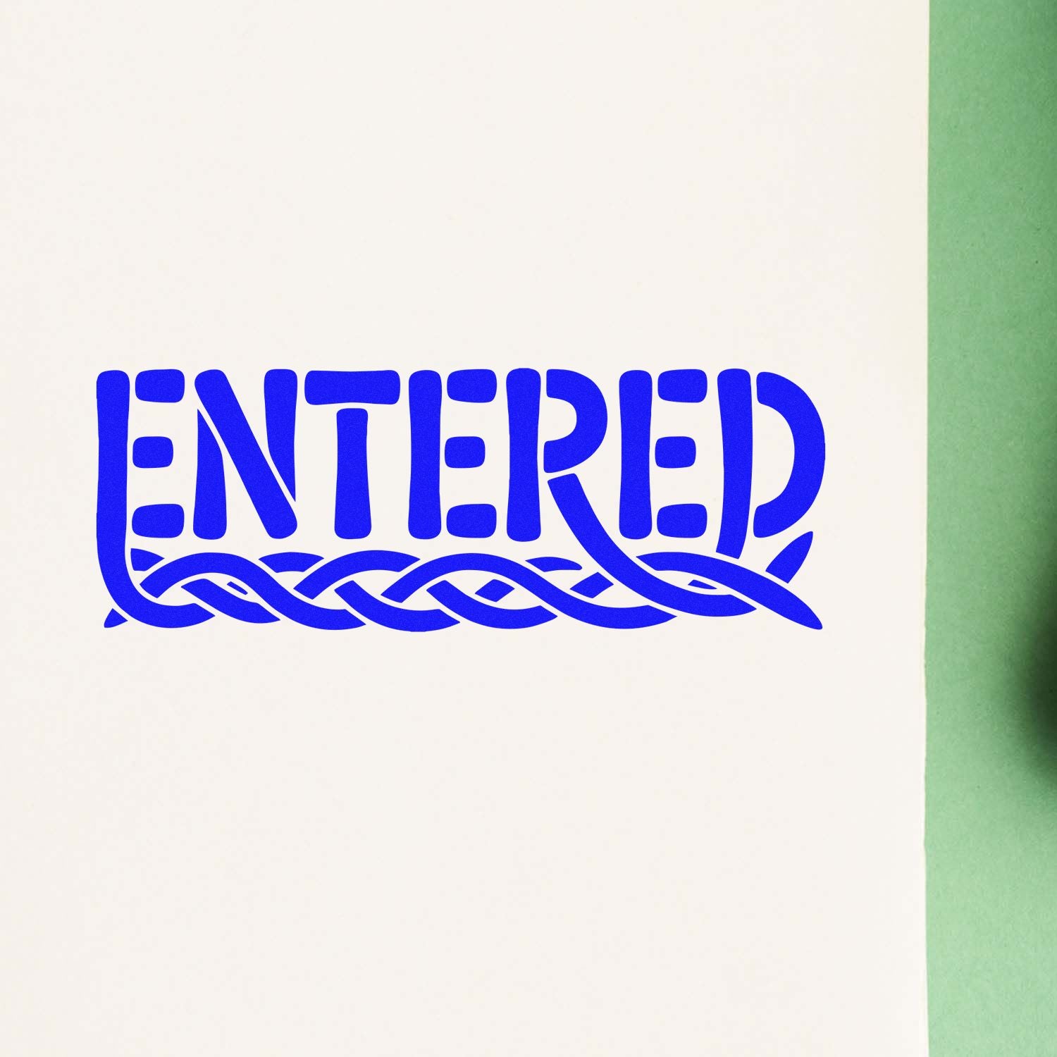 Blue ENTERED stamp seal with decorative braided border on white paper, beside a green edge