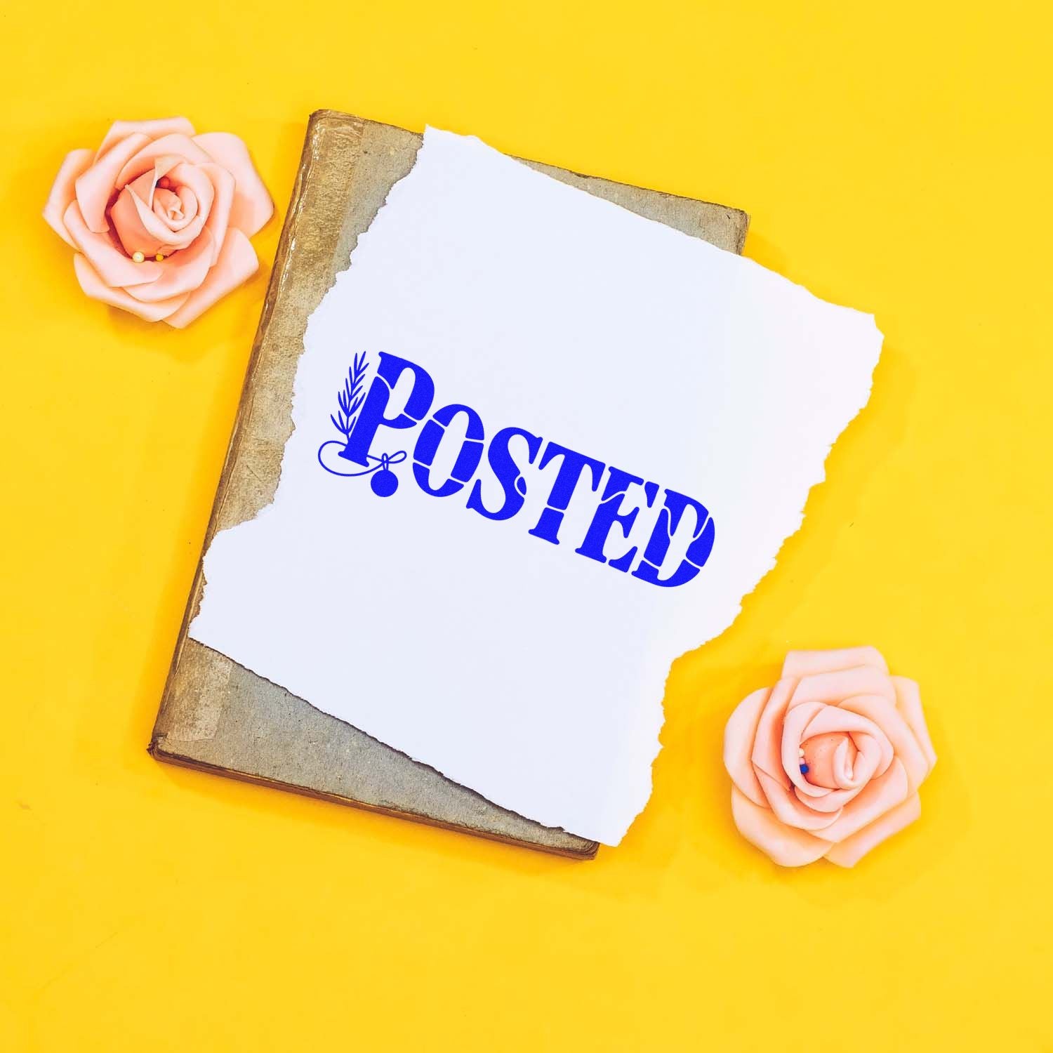 Blue POSTED stamp and pink rose seal products on torn white paper over an old book, against a bright yellow background