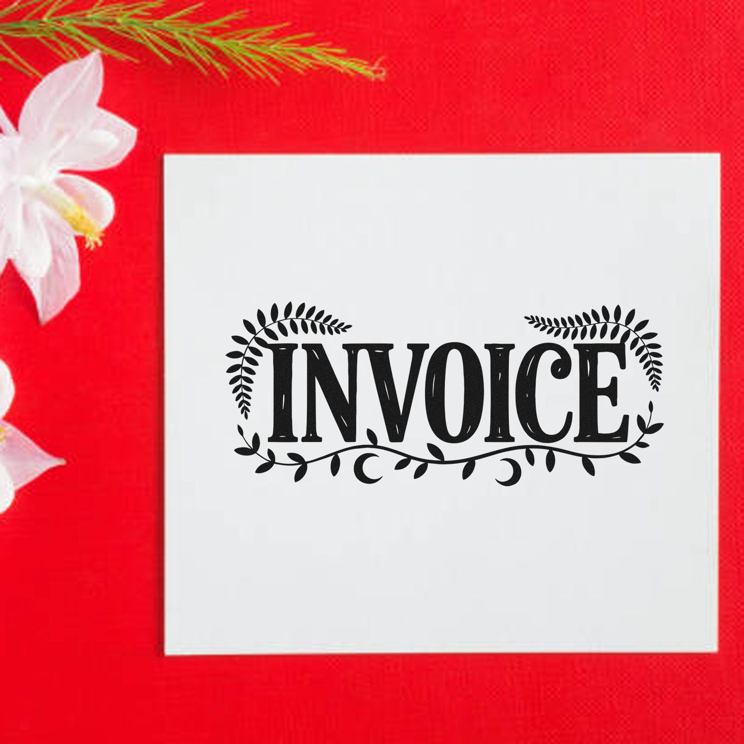 White invoice stamp seal with black leafy design on a red background, beside white flowers.