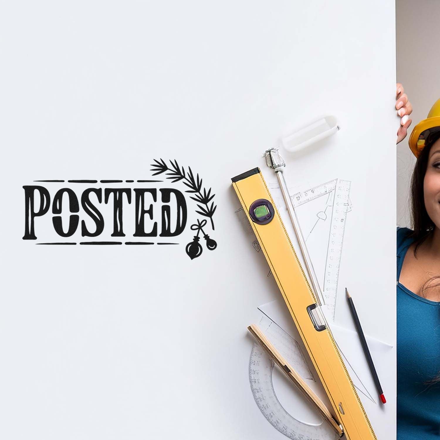 Black POSTED rubber stamp with leaf seal on white board, beside yellow level, rulers and pencil.