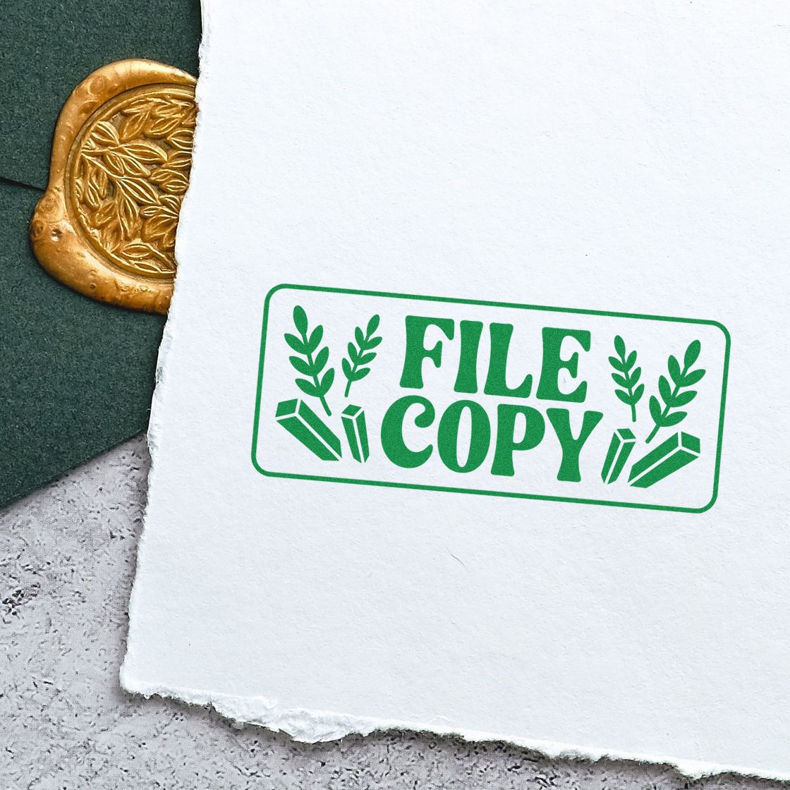 Green FILE COPY rubber stamp on torn white paper, beside a gold wax seal on dark green paper.