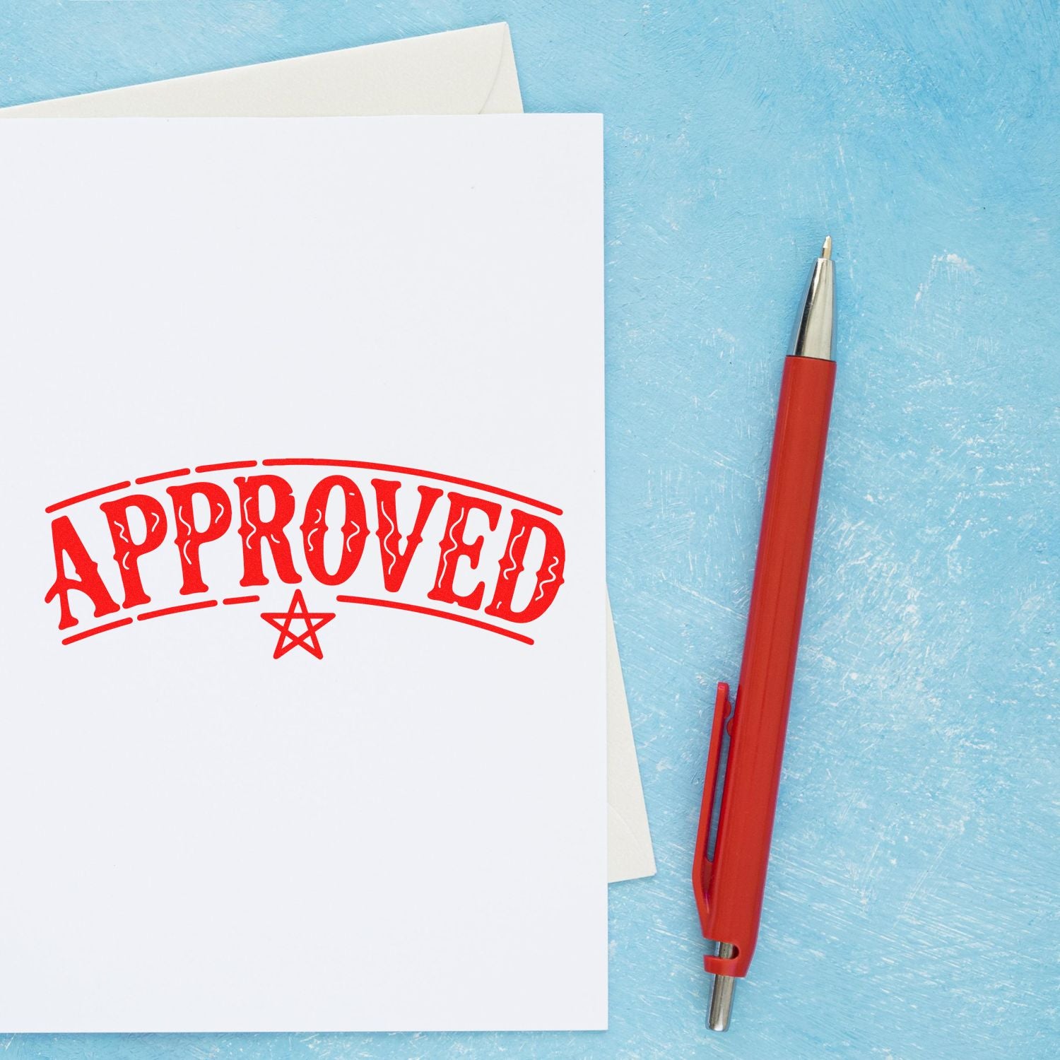 Red APPROVED stamp on white paper beside a red ballpoint pen on a light blue background.