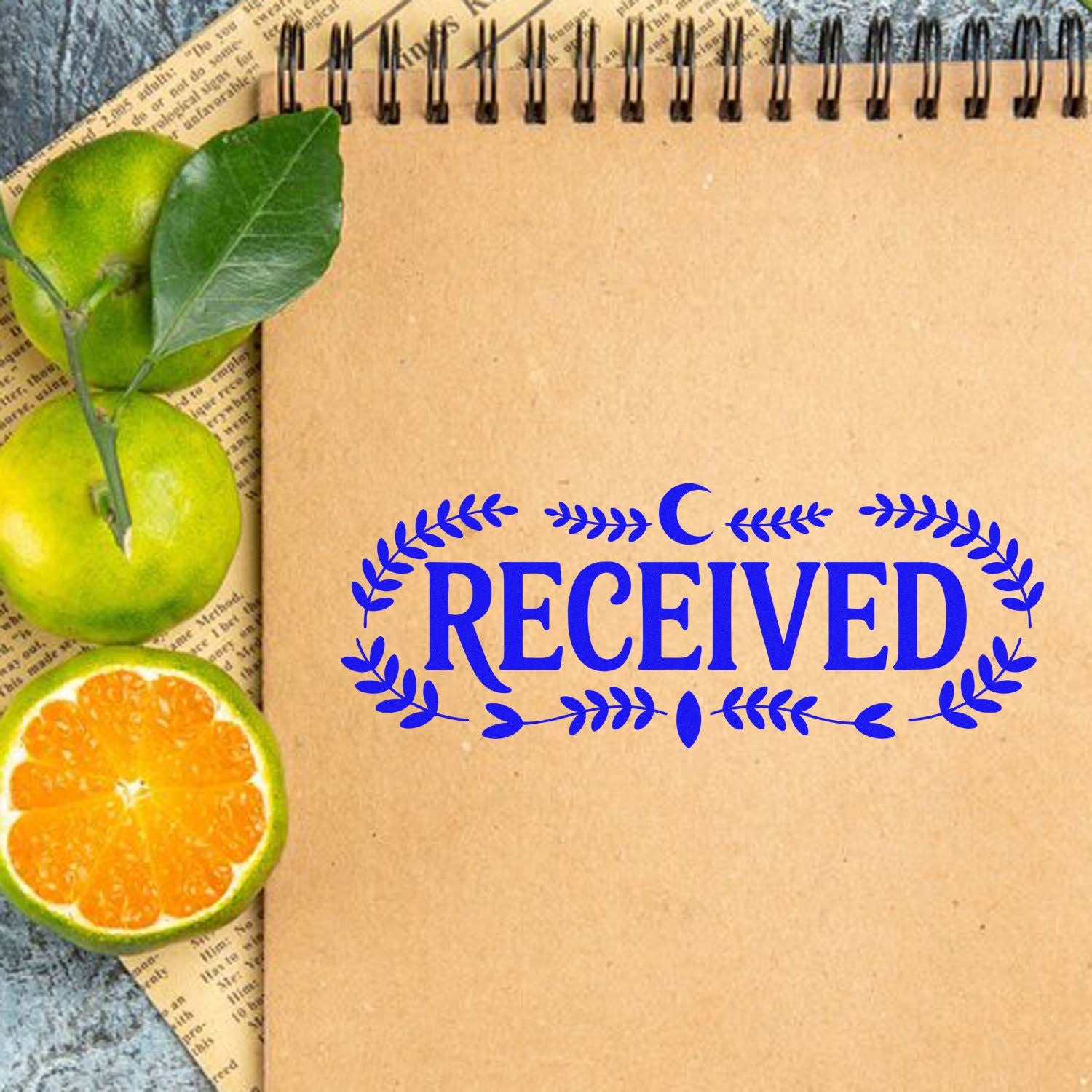 Brown spiral notebook with blue RECEIVED seal stamp, framed by green leaves and orange slices.