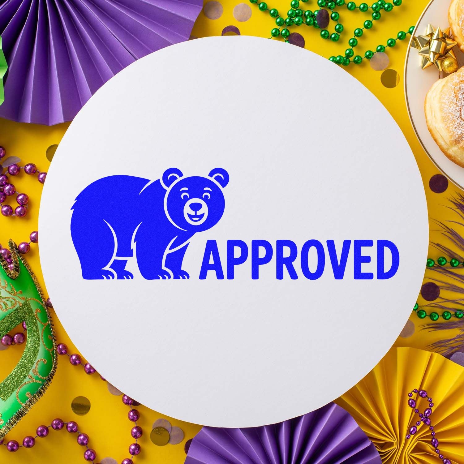 Blue bear APPROVED stamp on a white circular seal, surrounded by purple, gold, and green Mardi Gras decorations.