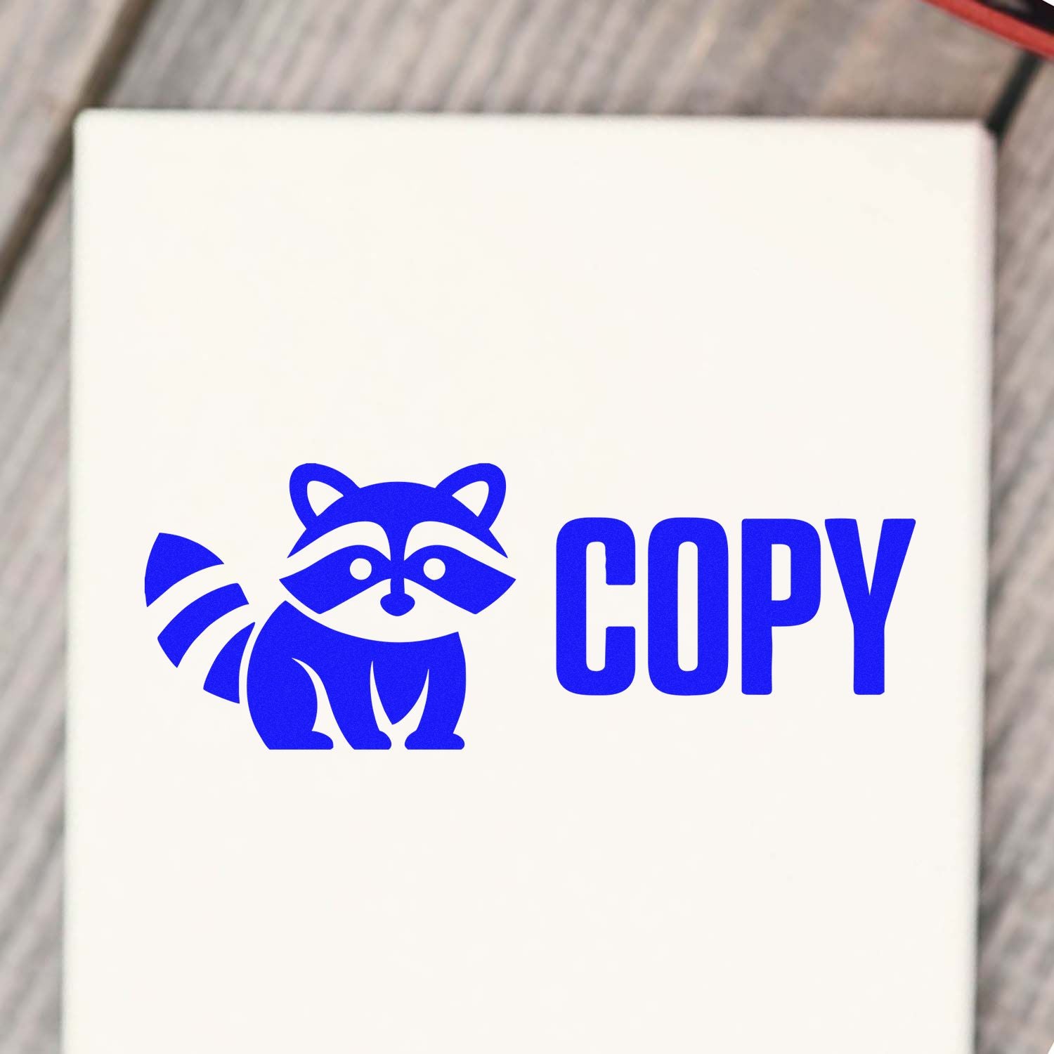 Blue raccoon logo with COPY text on a white stamp and seal product, bold blue imprint.