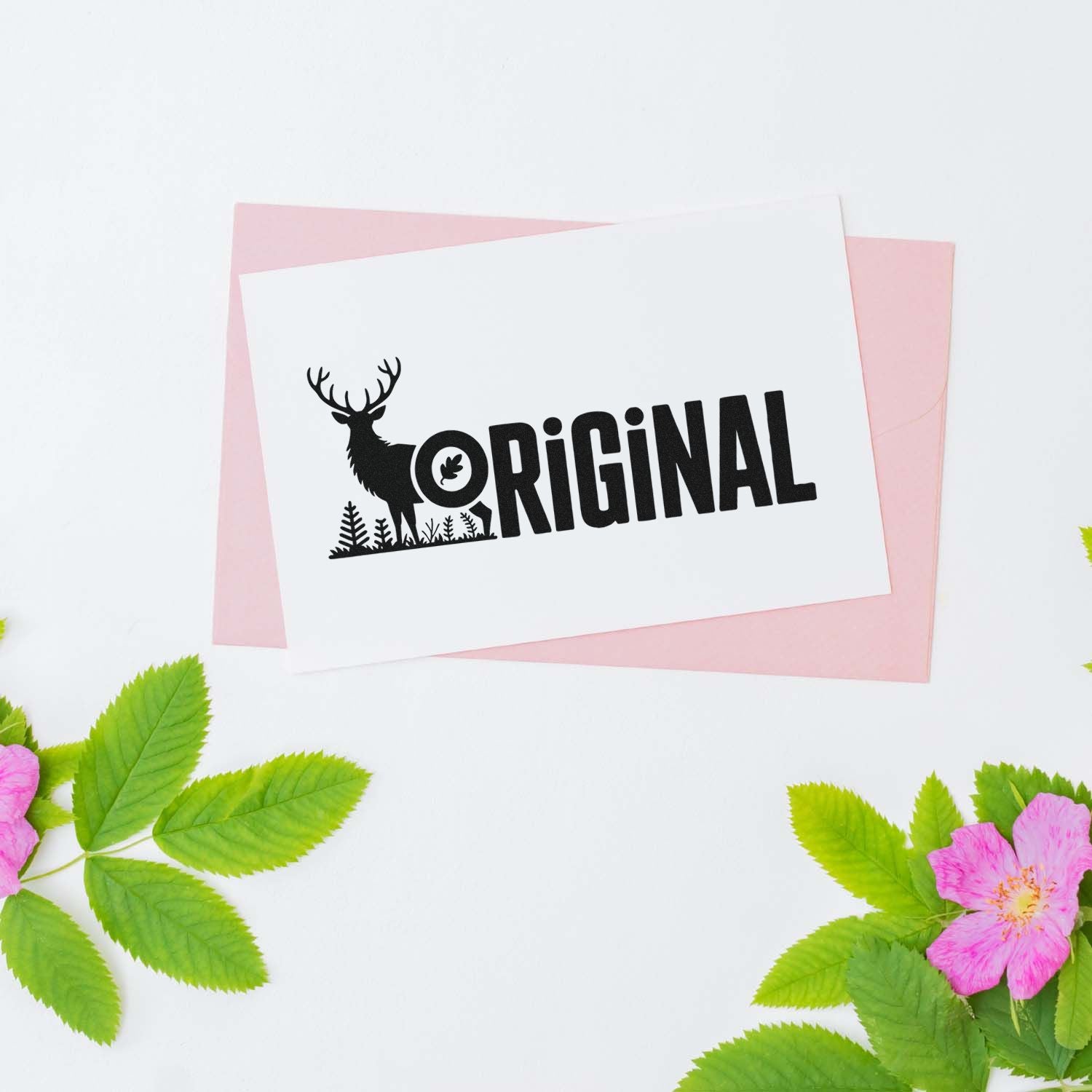 Black ORIGINAL deer stamp seal on white card with pink backing, green leaves, and pink flowers.