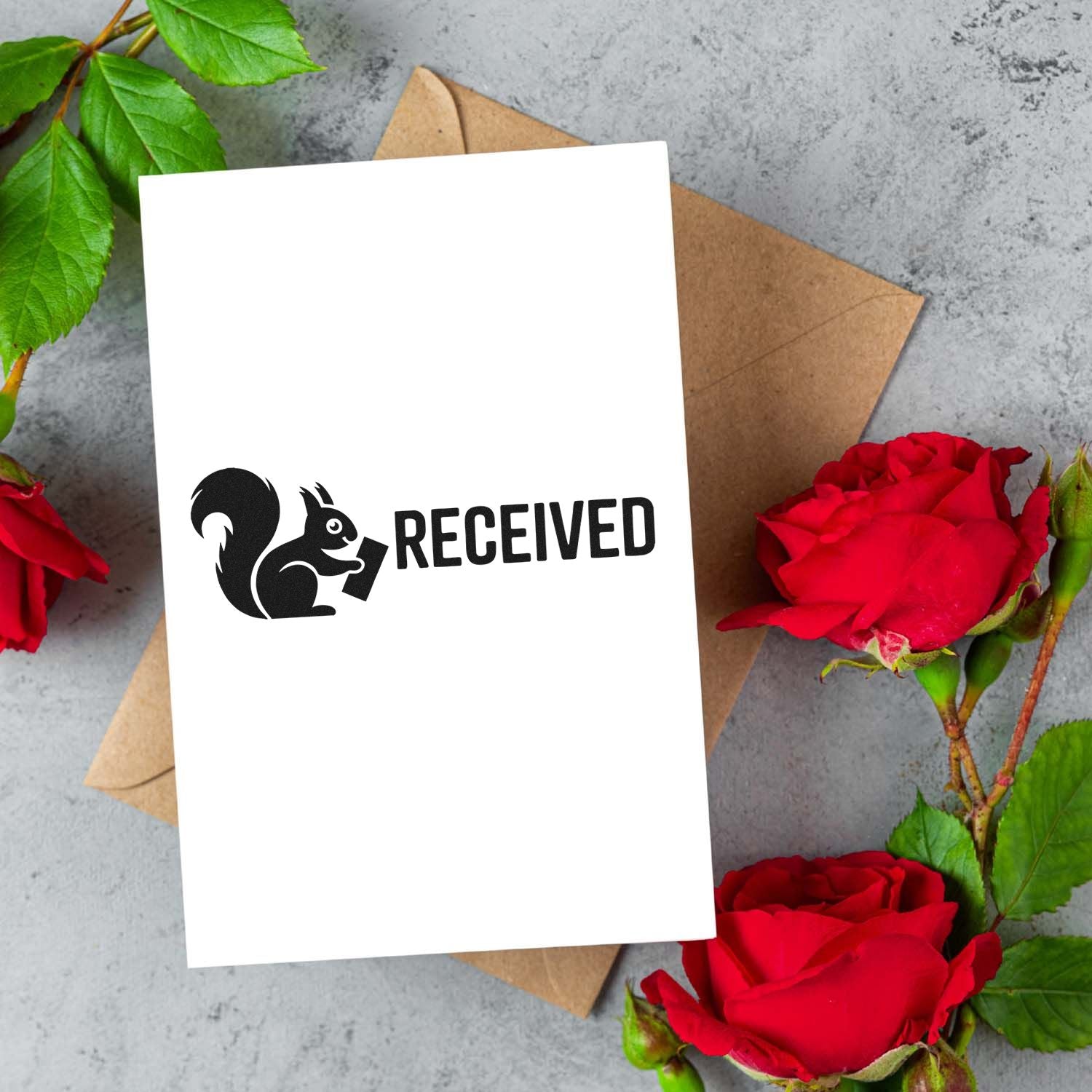 Black squirrel RECEIVED stamp seal on white card, over a brown envelope, with red roses and green leaves.