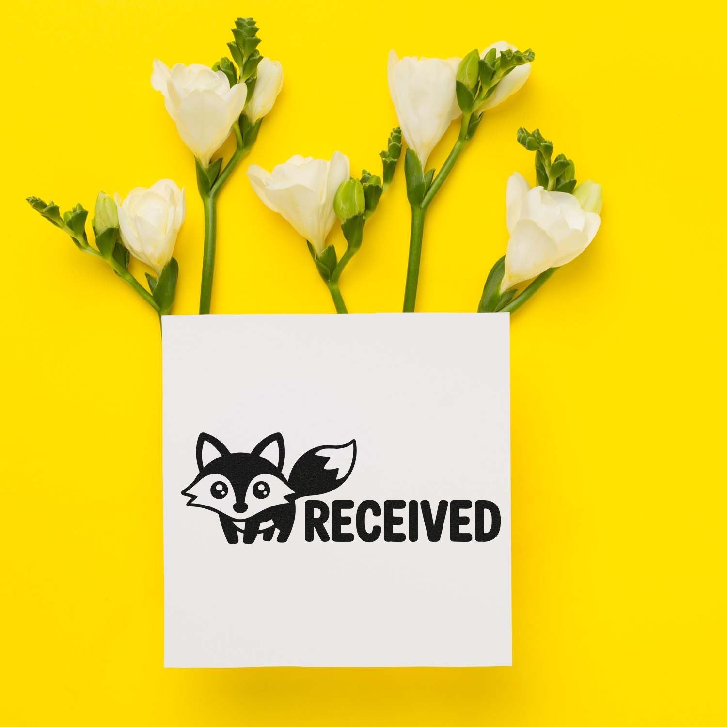Black fox RECEIVED rubber stamp on white paper, framed by white flowers and green stems on a bright yellow background.