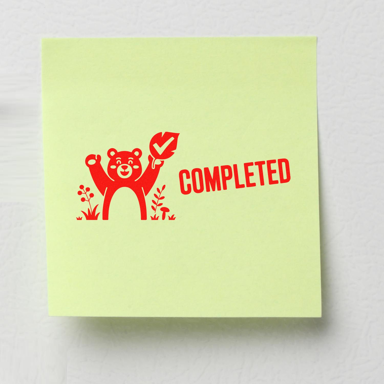 Red completed rubber stamp seal with bear and check mark on pale yellow-green paper