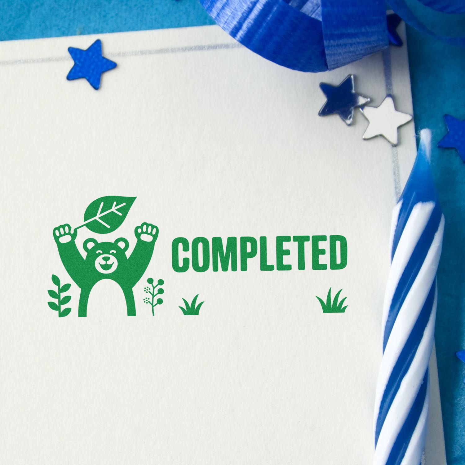 Green completed stamp and seal with bear and leaf, on white paper with blue ribbon and star accents.