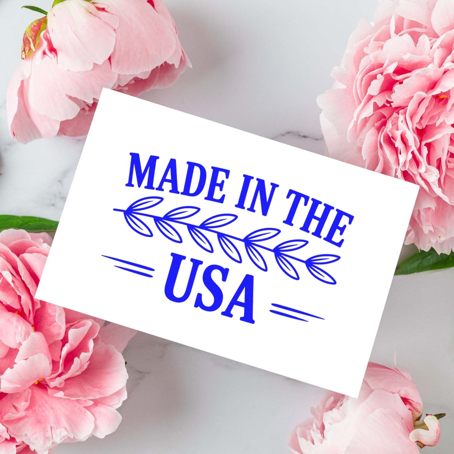 Blue Made in the USA stamp and seal on a white card, framed by pink peonies.