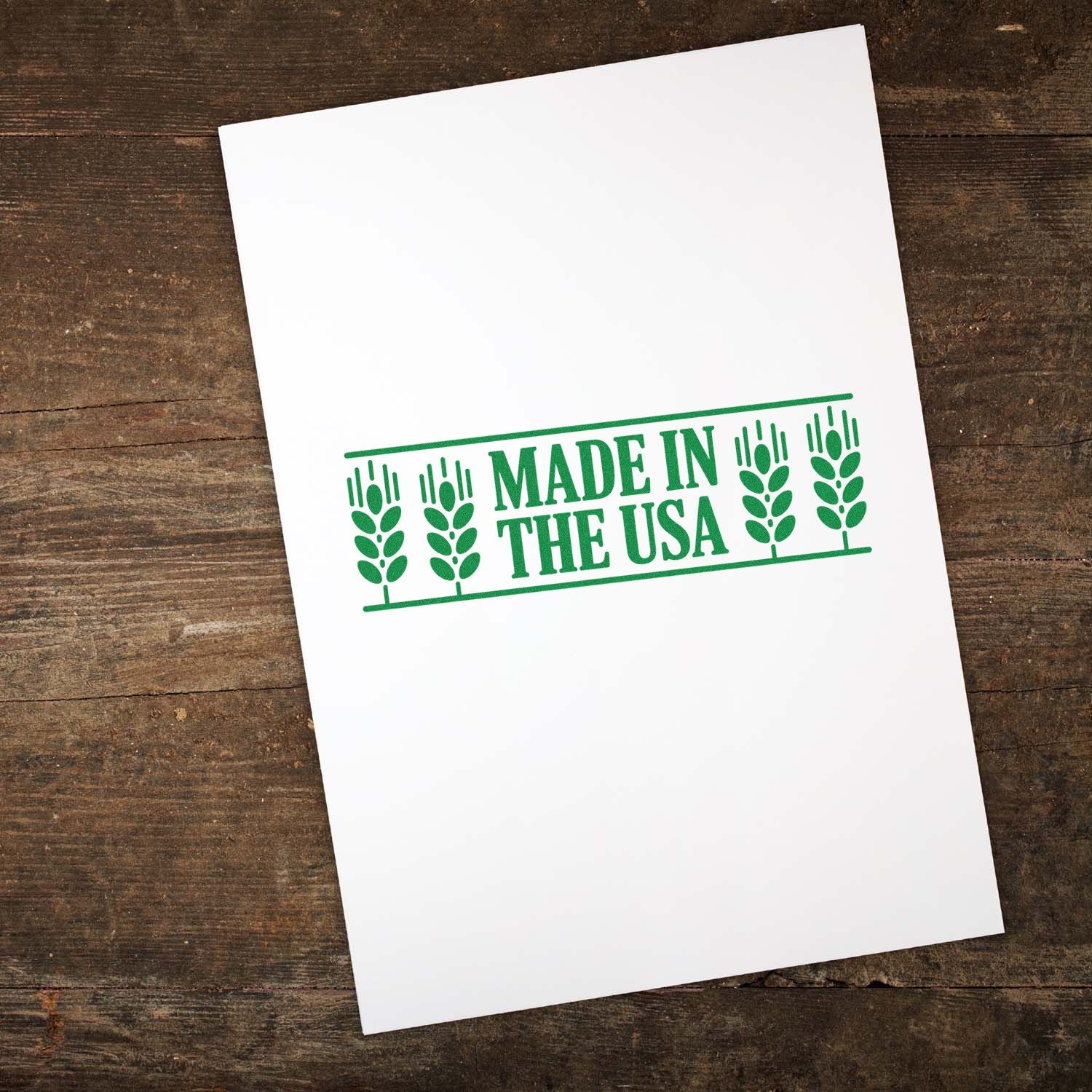 White paper with green Made in the USA stamp seal and wheat motif on rustic wood background