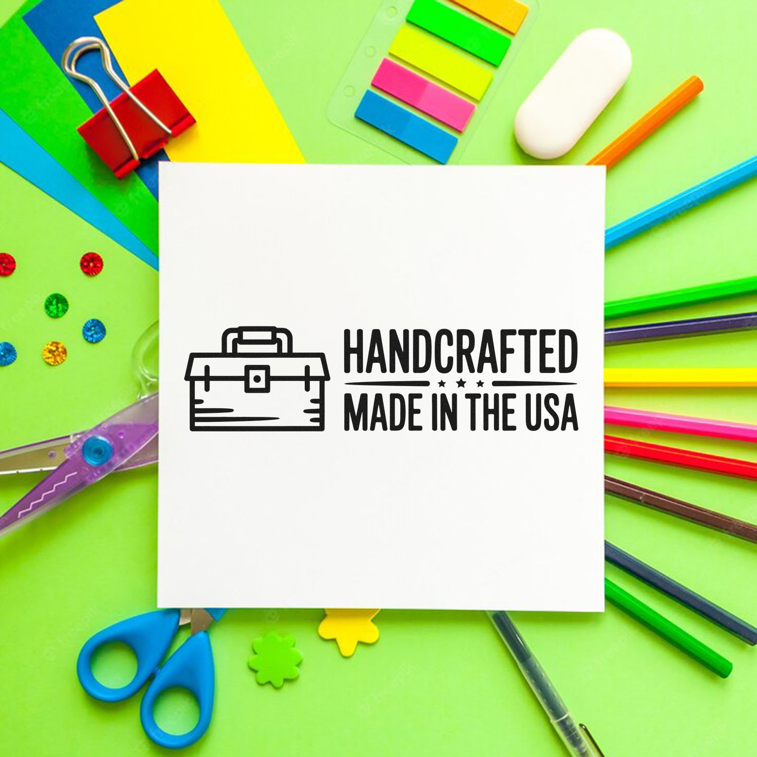 Black handcrafted Made in the USA stamp seal on white card, surrounded by colorful stationery on a lime green background.
