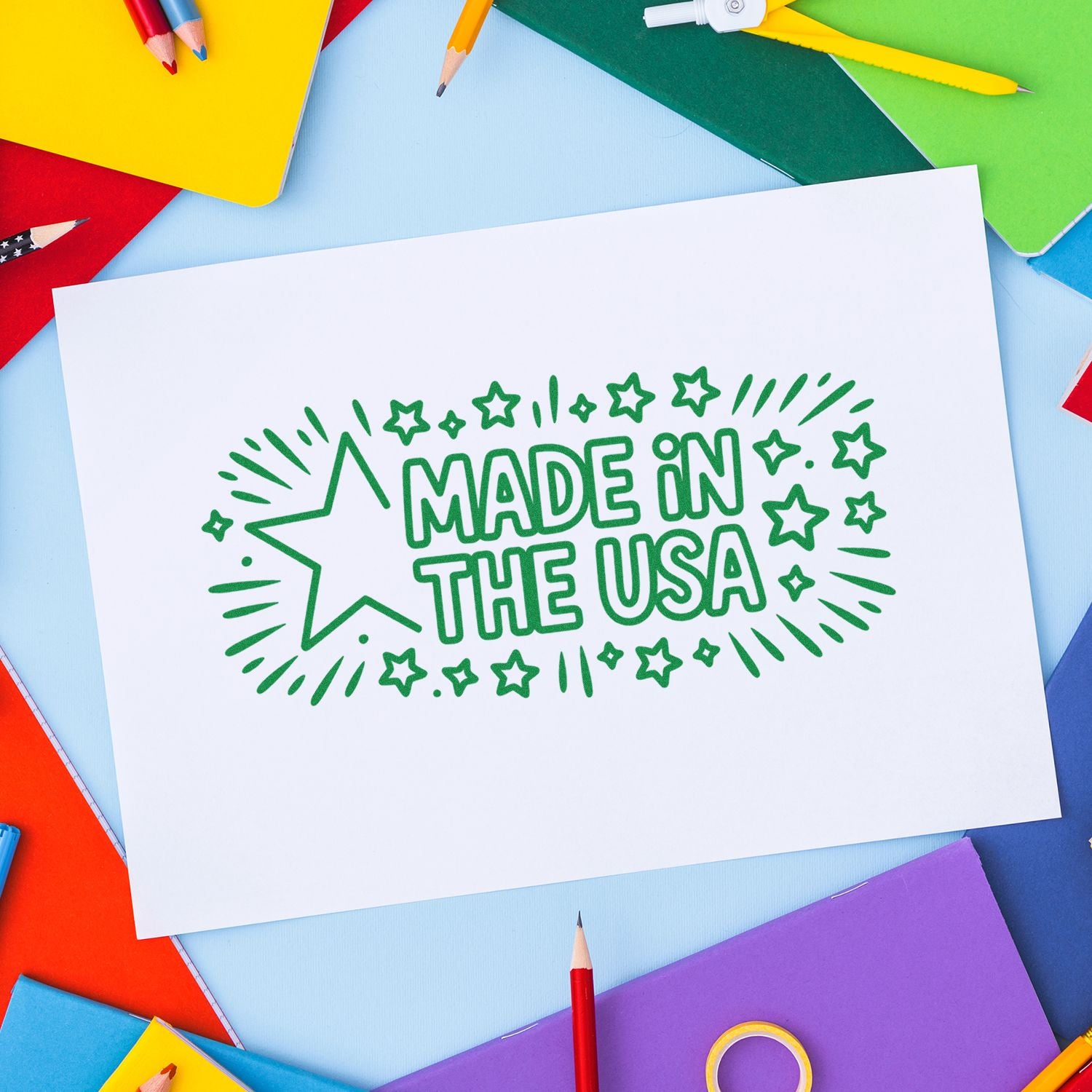 Green Made in the USA stamp seal on white paper, framed by colorful pencils, notebooks, and office supplies.