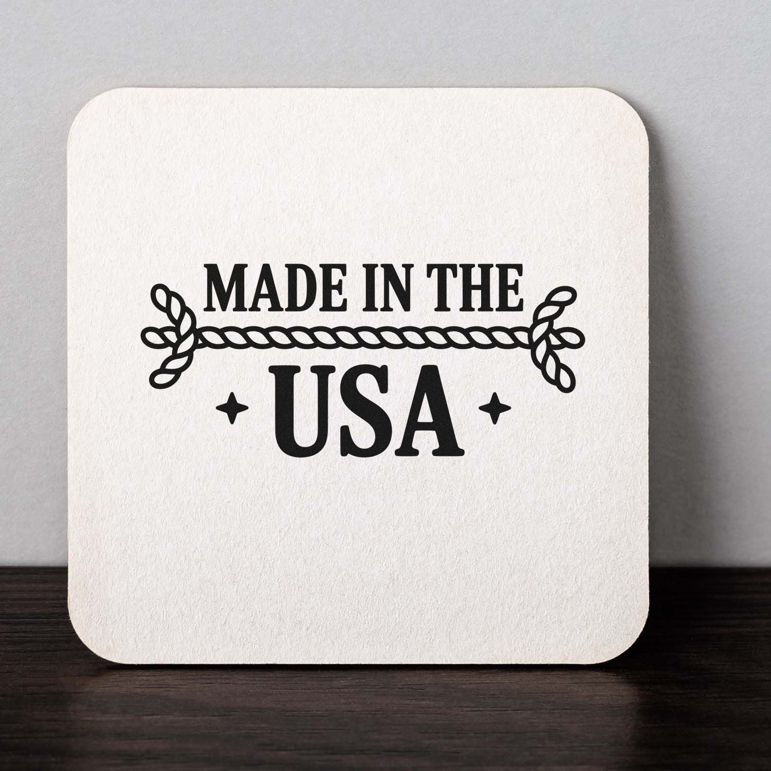 Black Made in the USA stamp and seal with rope border on a white textured square card.