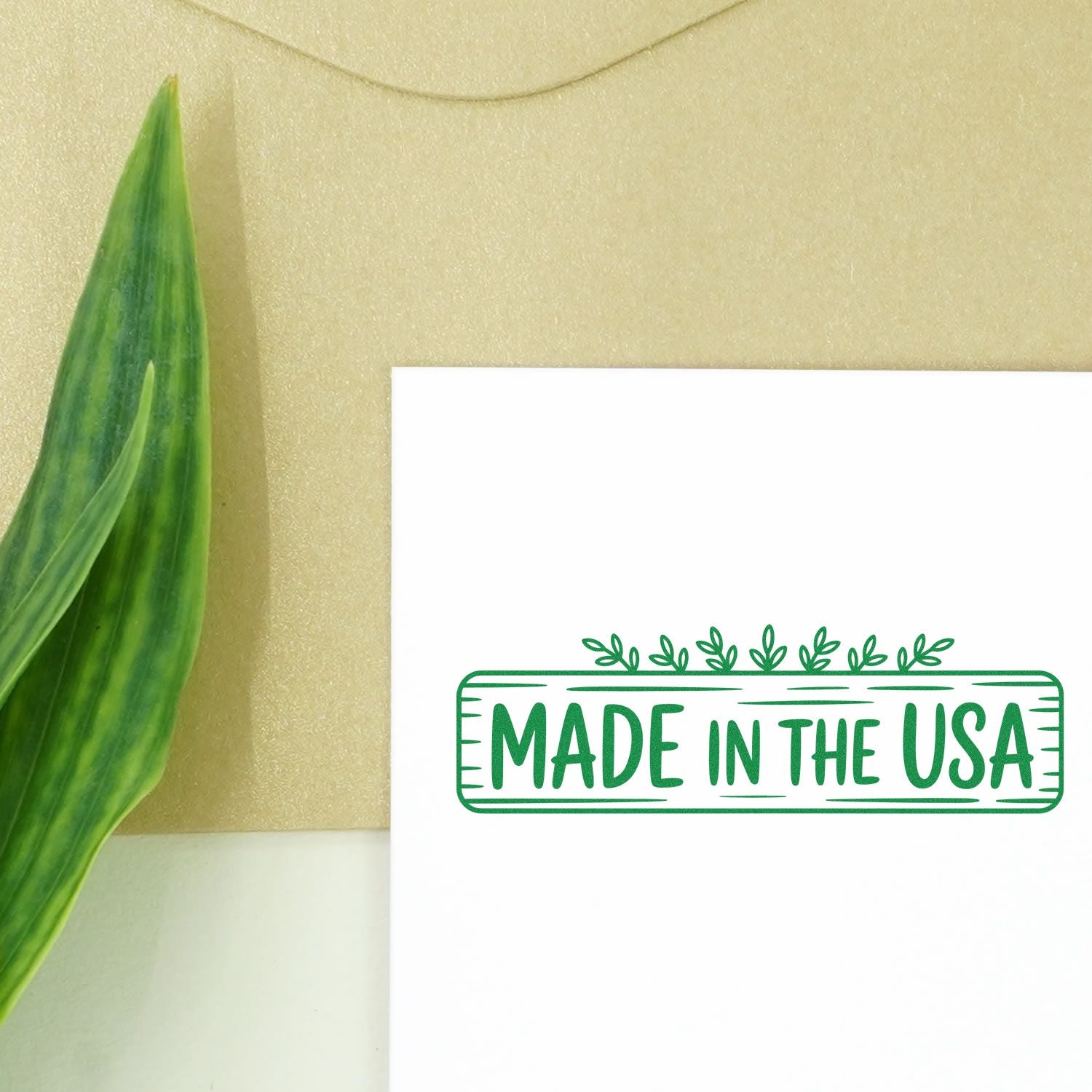 Green Made in the USA stamp and seal on white card, with leafy detail beside a green leaf on beige background.
