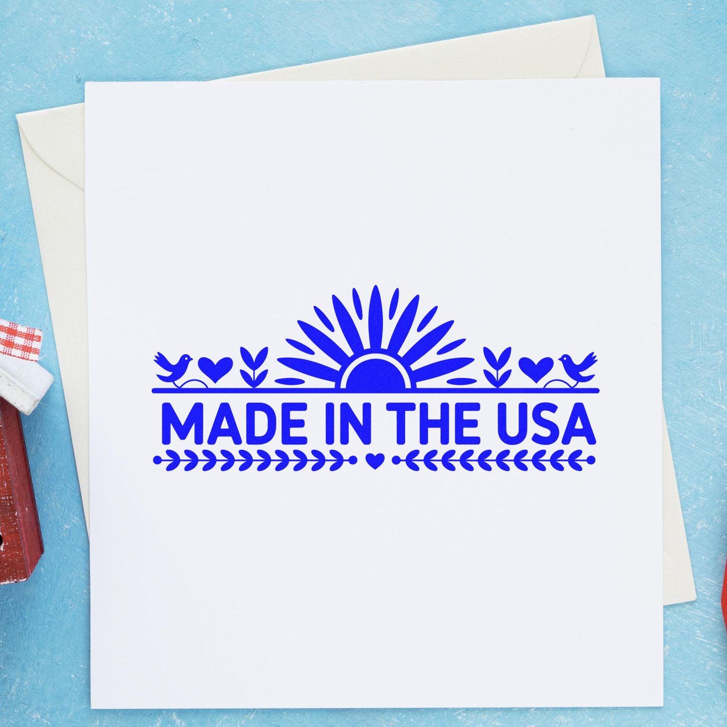 Blue Made in the USA stamp and seal design with sunburst, birds, hearts and leaves on white paper.