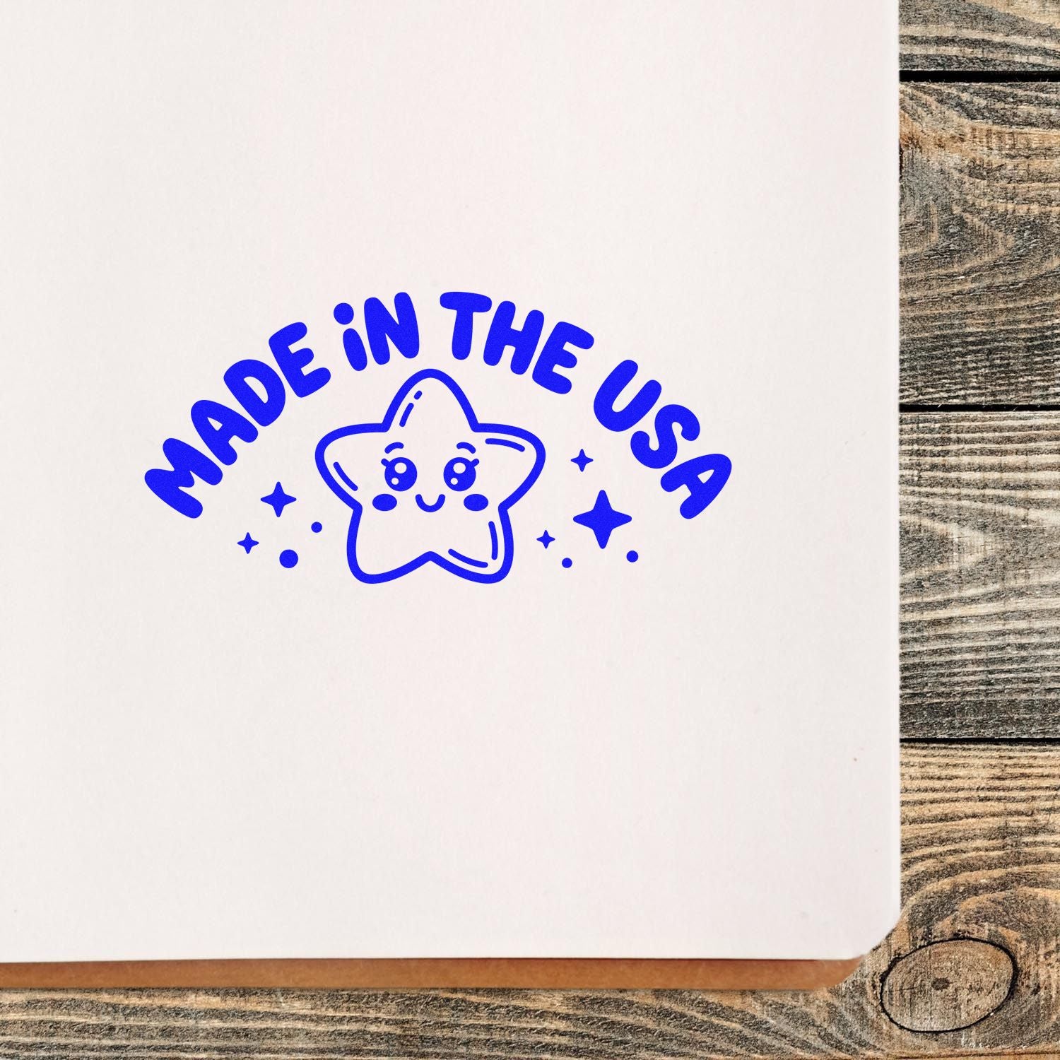 Blue Made in the USA stamp and seal with smiling star and sparkles on white paper.