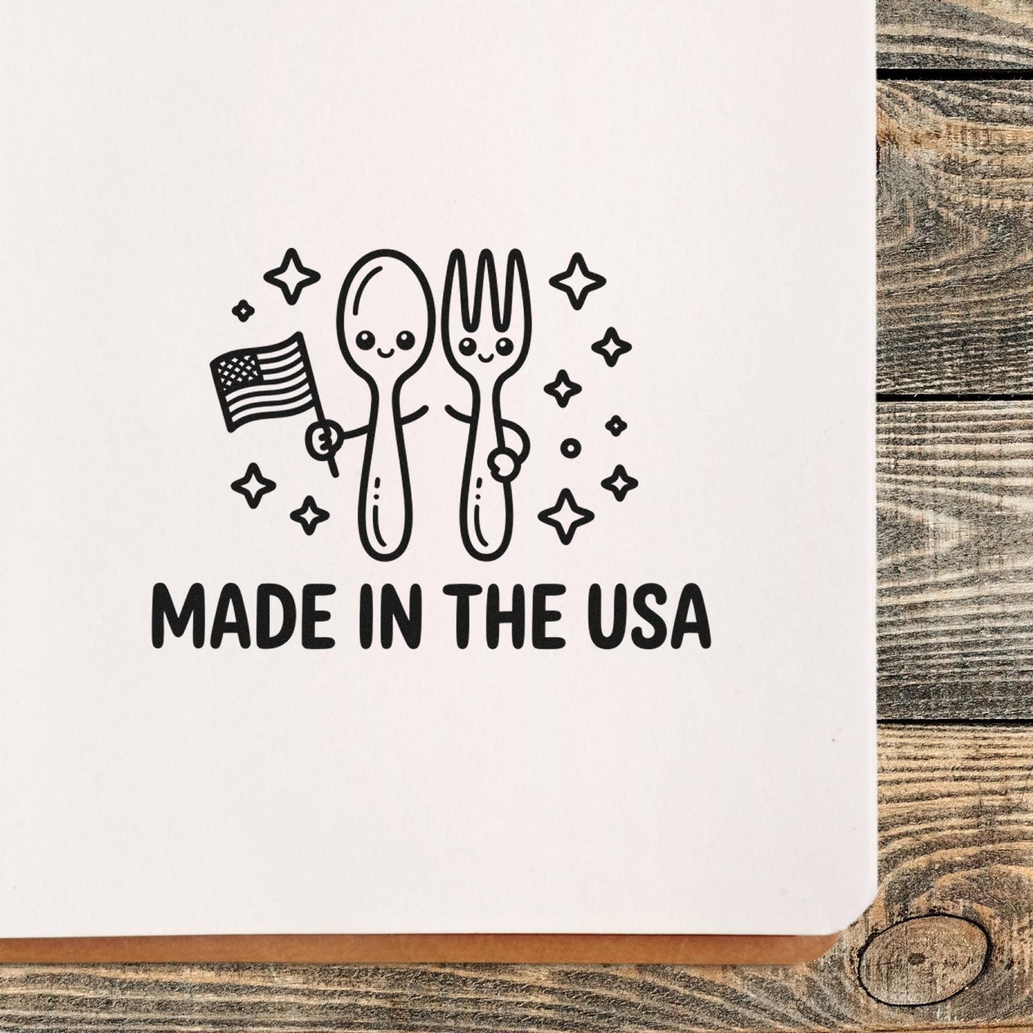 Black Made in the USA stamp with smiling spoon and fork, stars, and an American flag on white paper.