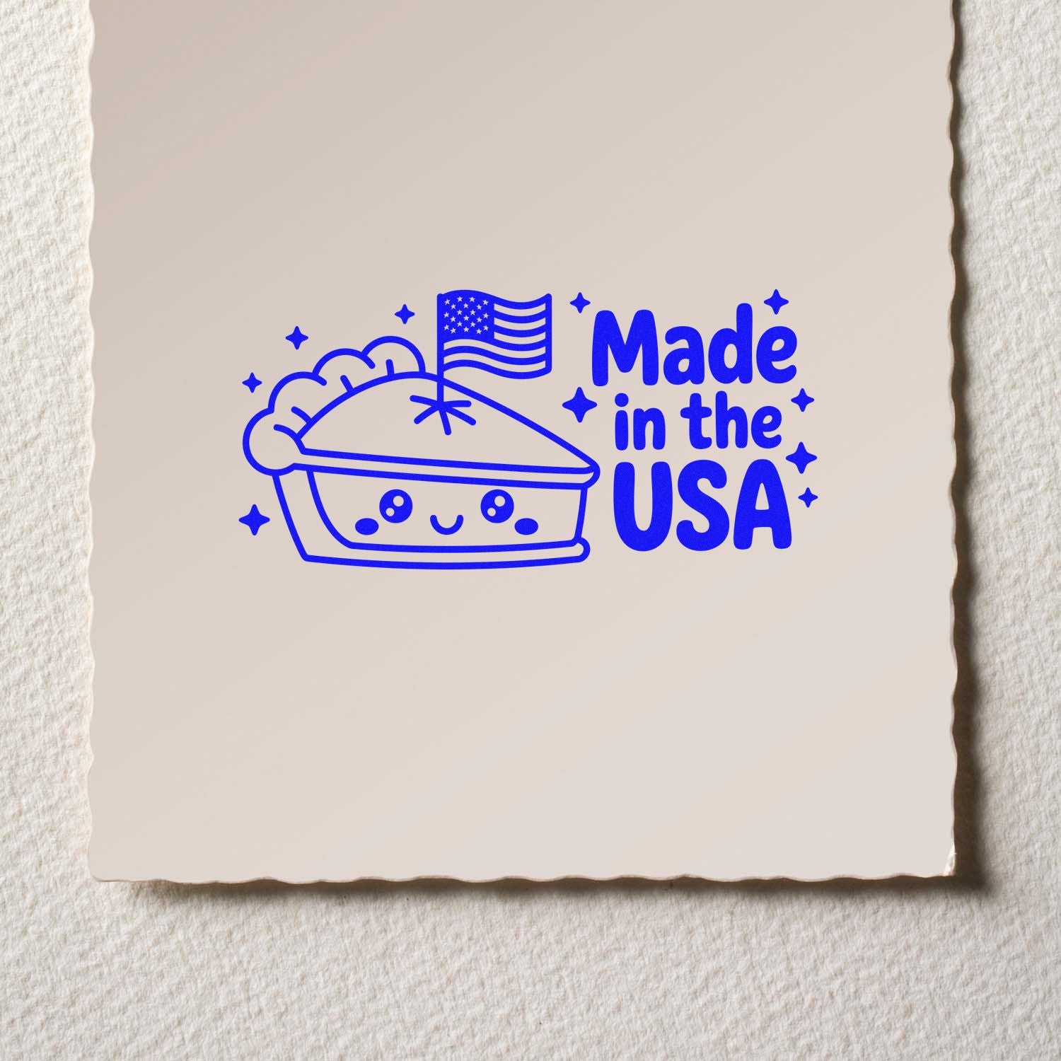 Blue Made in the USA pie stamp/seal with American flag, stars, and a cute face on beige paper.