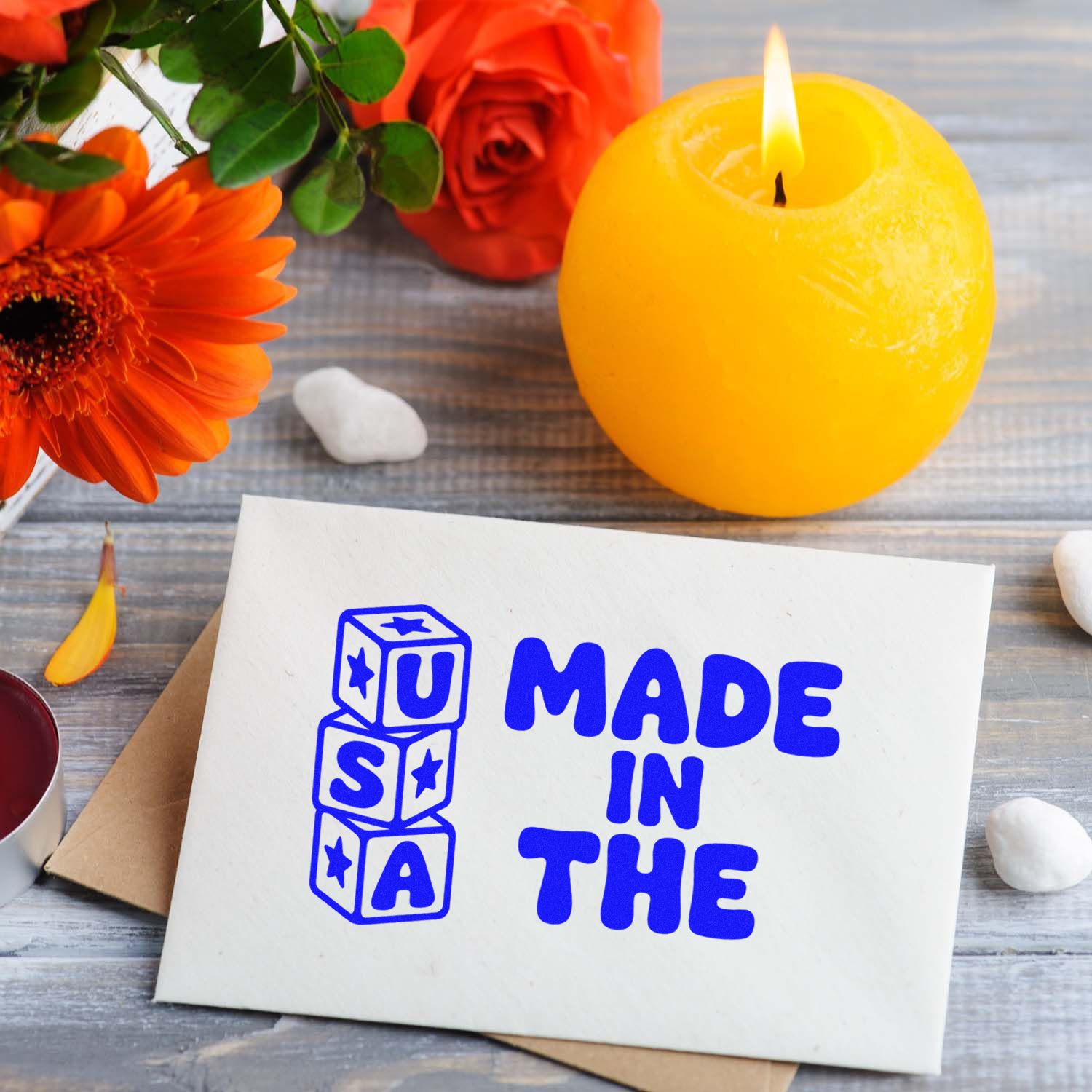 Blue Made in the USA stamp and seal on white card with yellow candle, orange flowers, and red roses.