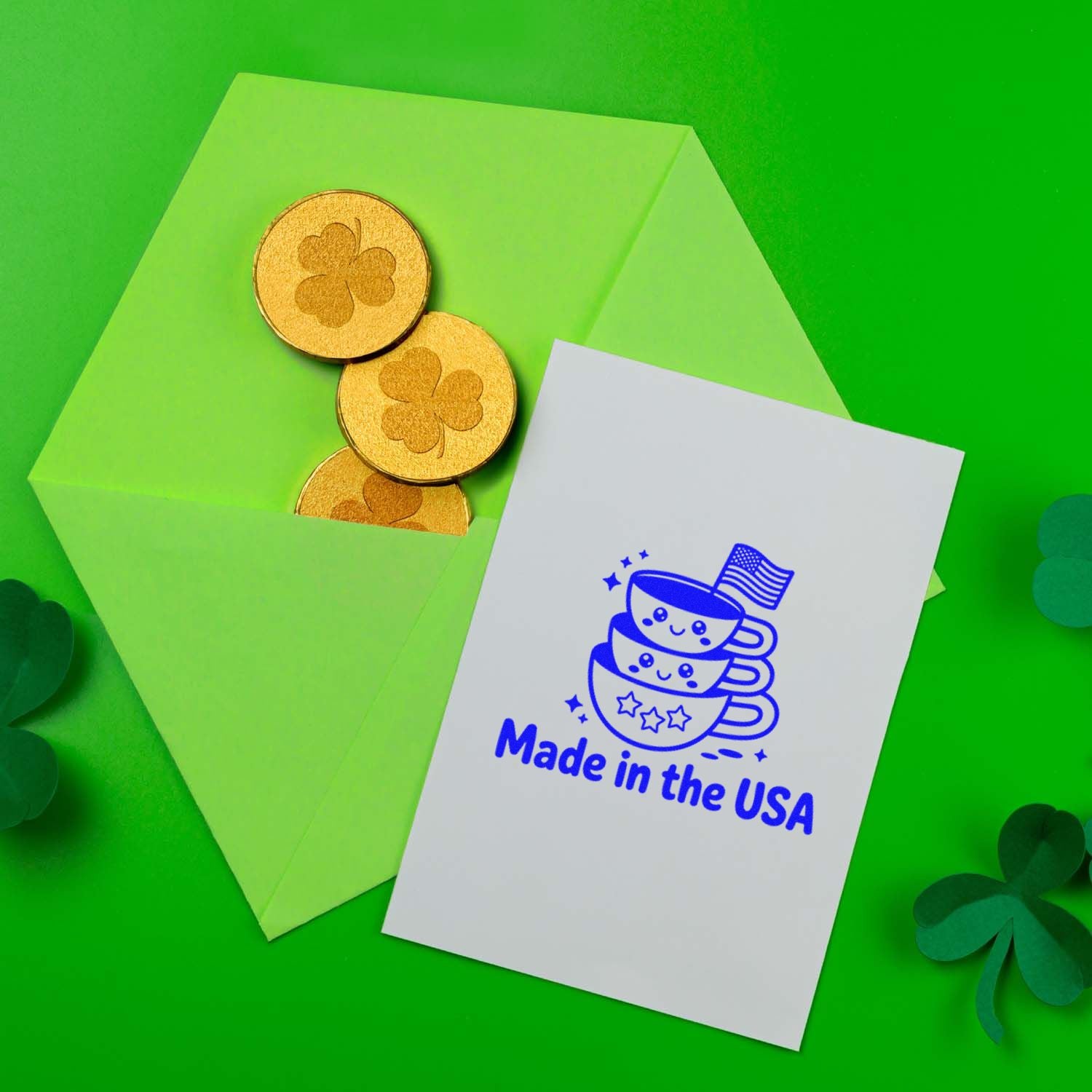 Bright green envelope with gold shamrock seal stamps and a white card stamped Made in the USA in blue.