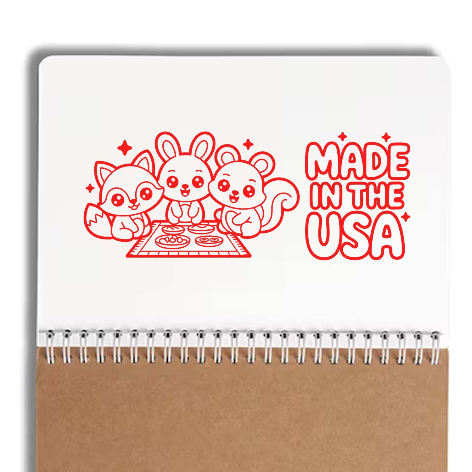 Red stamp and seal design with cute fox, bunny, and bear, plus Made in the USA text on a white notebook cover.