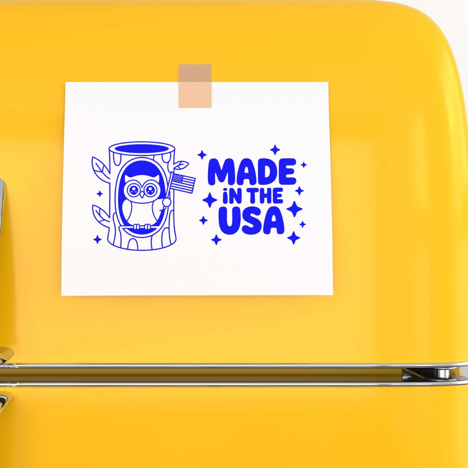 Blue Made in the USA stamp with owl in a log holding a flag on a white card, taped to a bright yellow background.