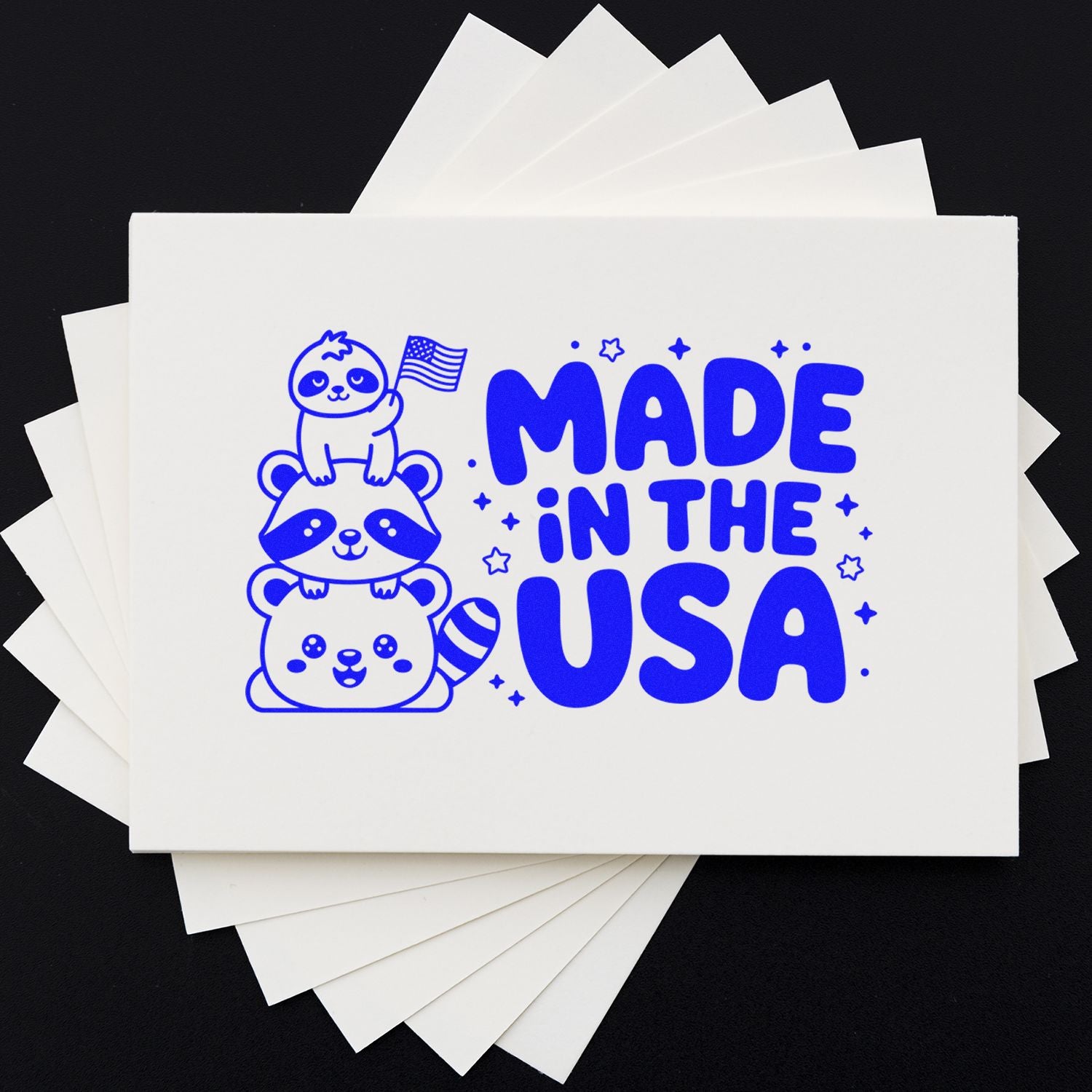 Blue Made in the USA stamp and seal design on white cards, featuring stacked cartoon raccoons and a U.S. flag.