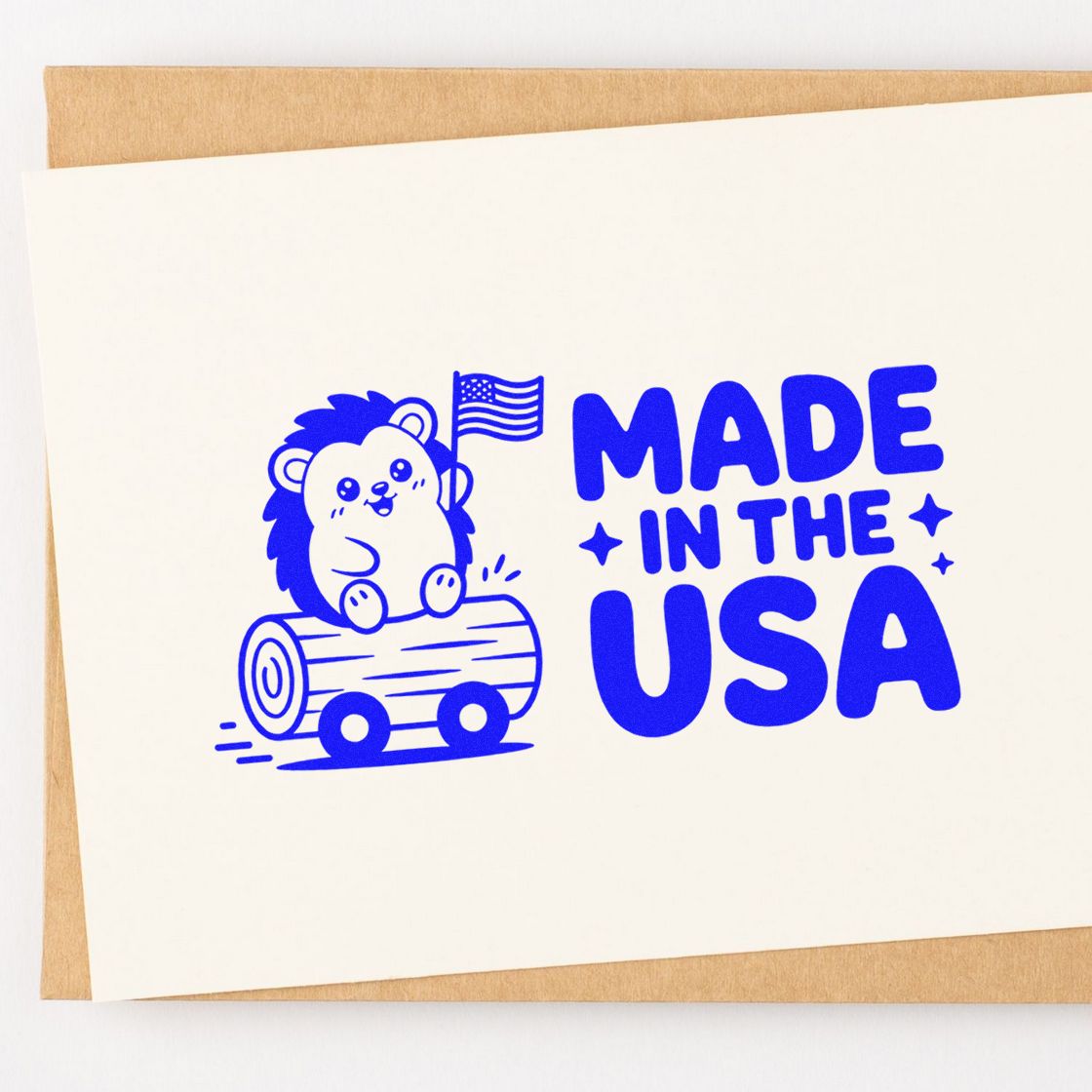 Blue Made in the USA rubber stamp with bear on log and U.S. flag on white card over kraft paper.