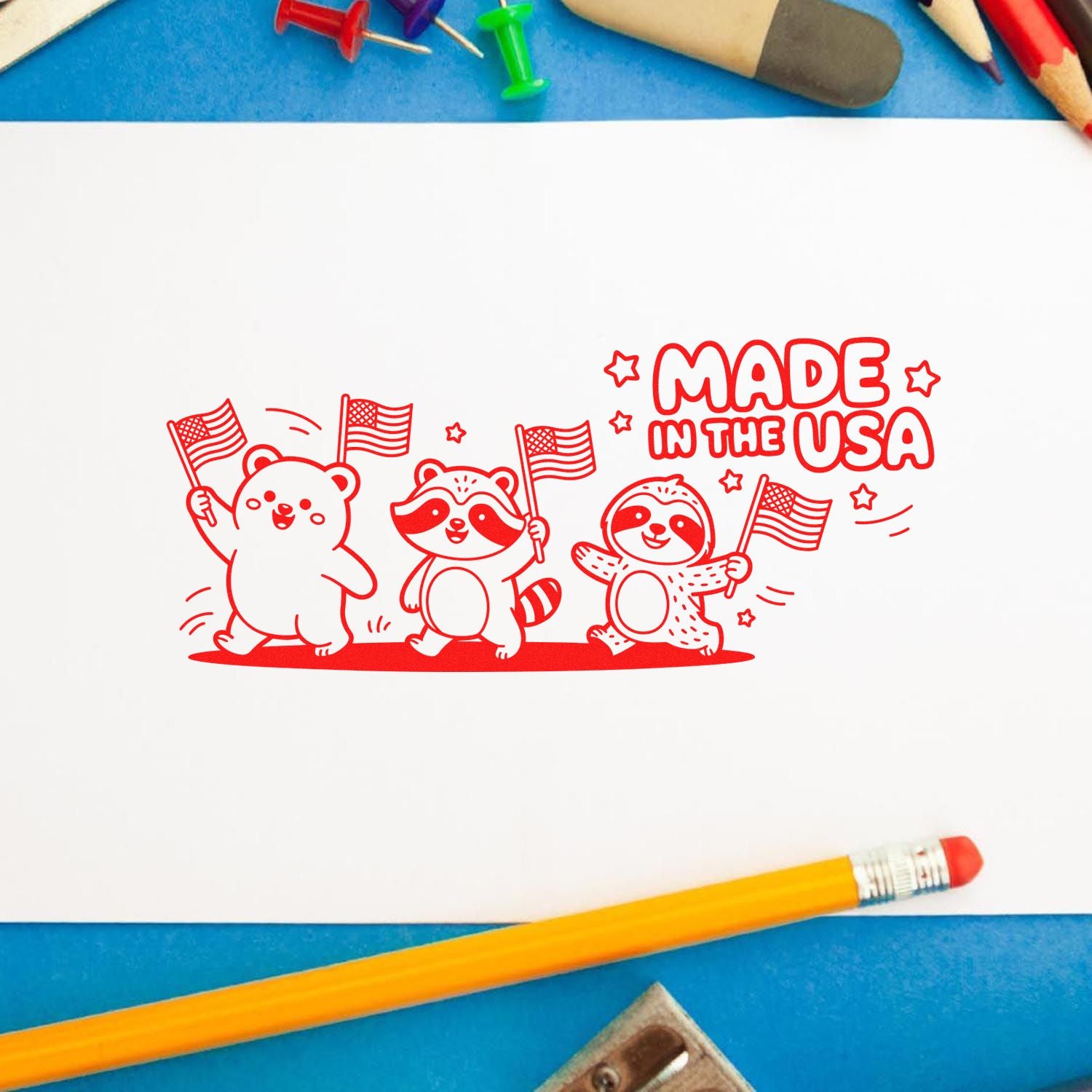 Red rubber stamp reading Made in the USA, with cartoon bear, raccoon and sloth waving American flags.
