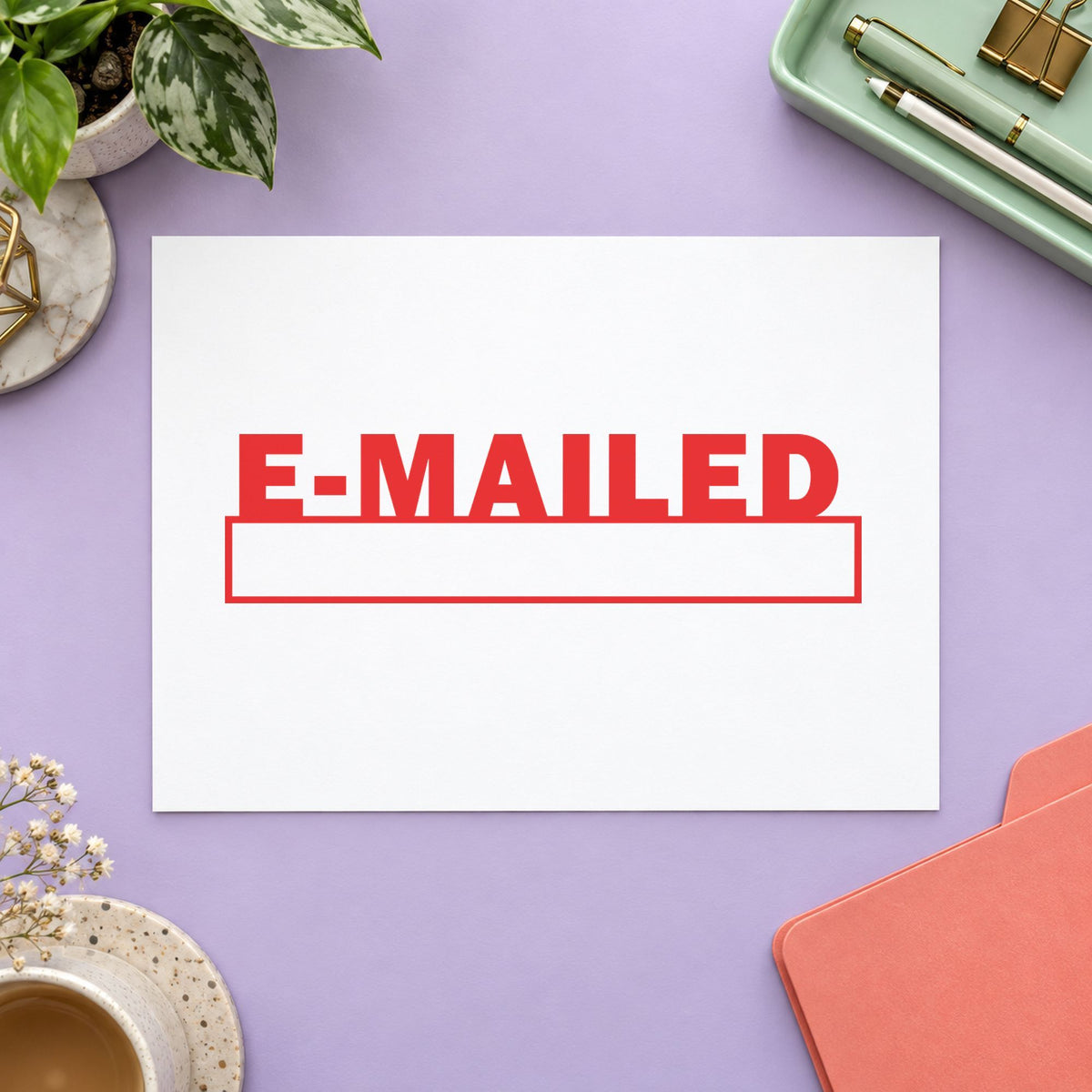 Pre-inked "E-mailed" stamp marking paperwork in an office setting