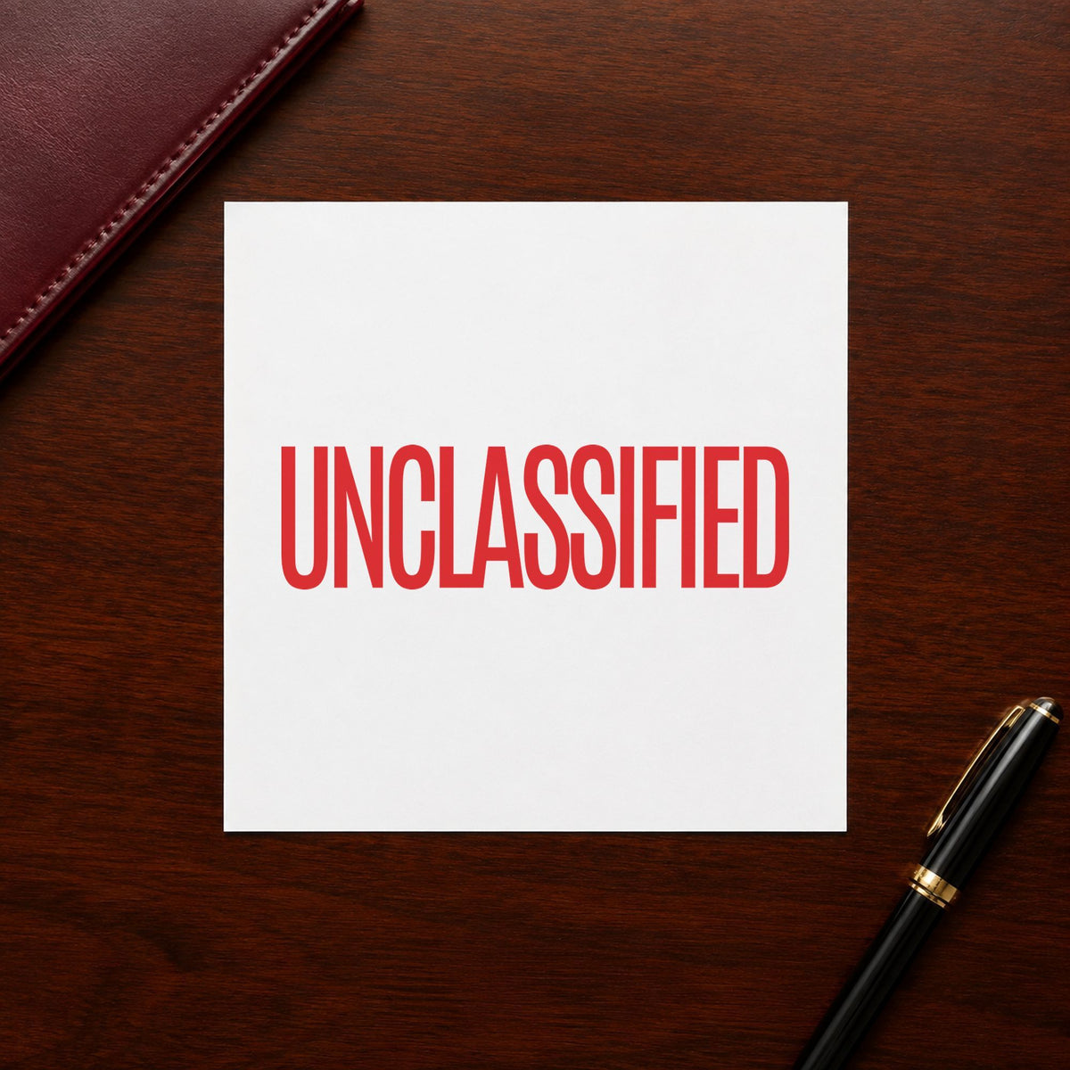 Pre-inked "Unclassified" stamp marking paperwork in an office setting
