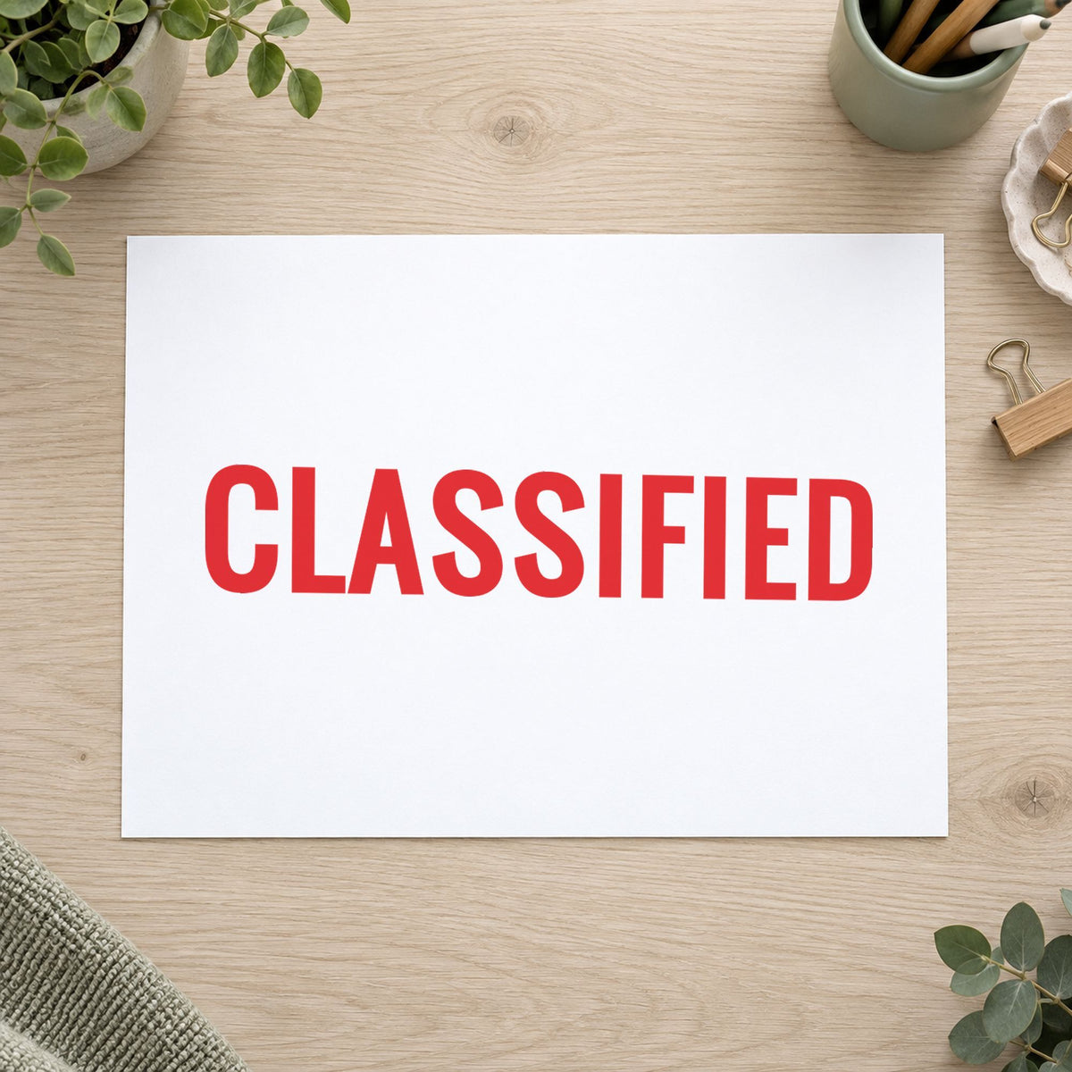 "Classified" Xstamper stamp in use on paper, 1/2 x 1-5/8 in rectangle imprint