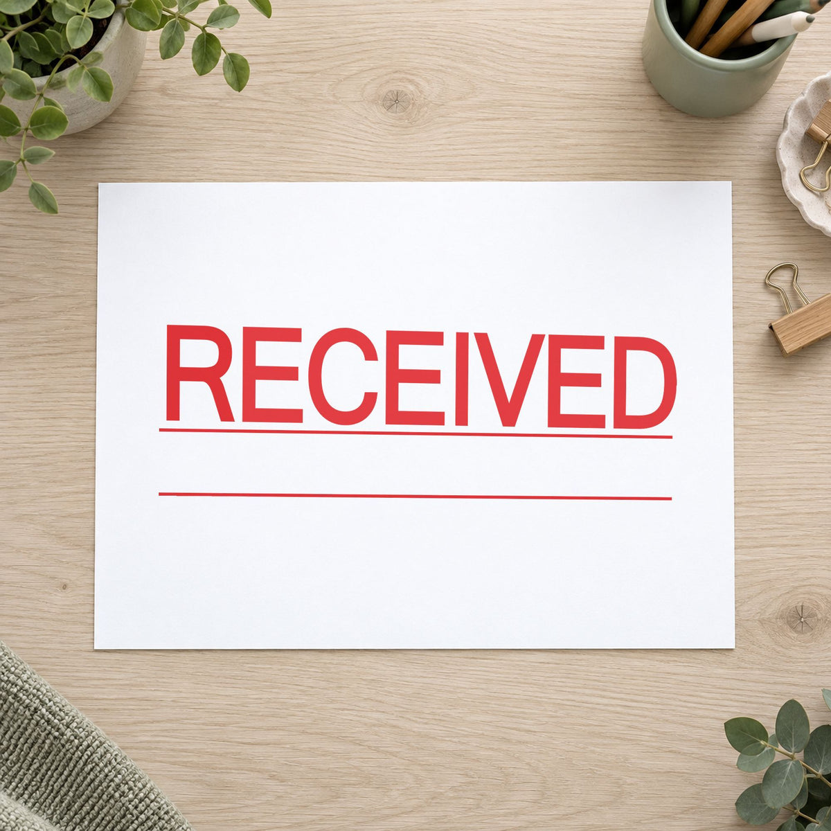 Pre-inked "Received" stamp marking paperwork in an office setting
