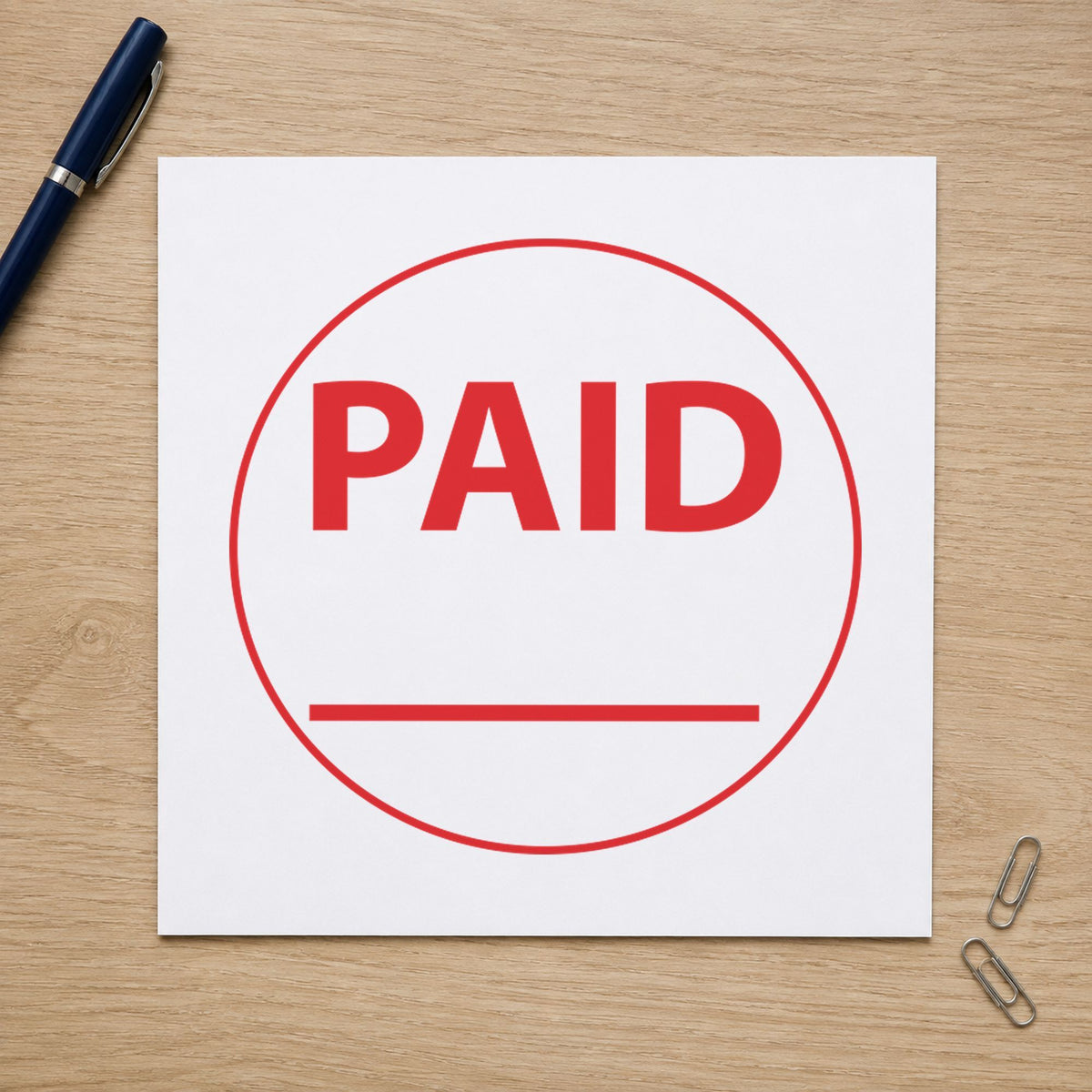 Pre-inked "Paid" stamp marking paperwork in an office setting