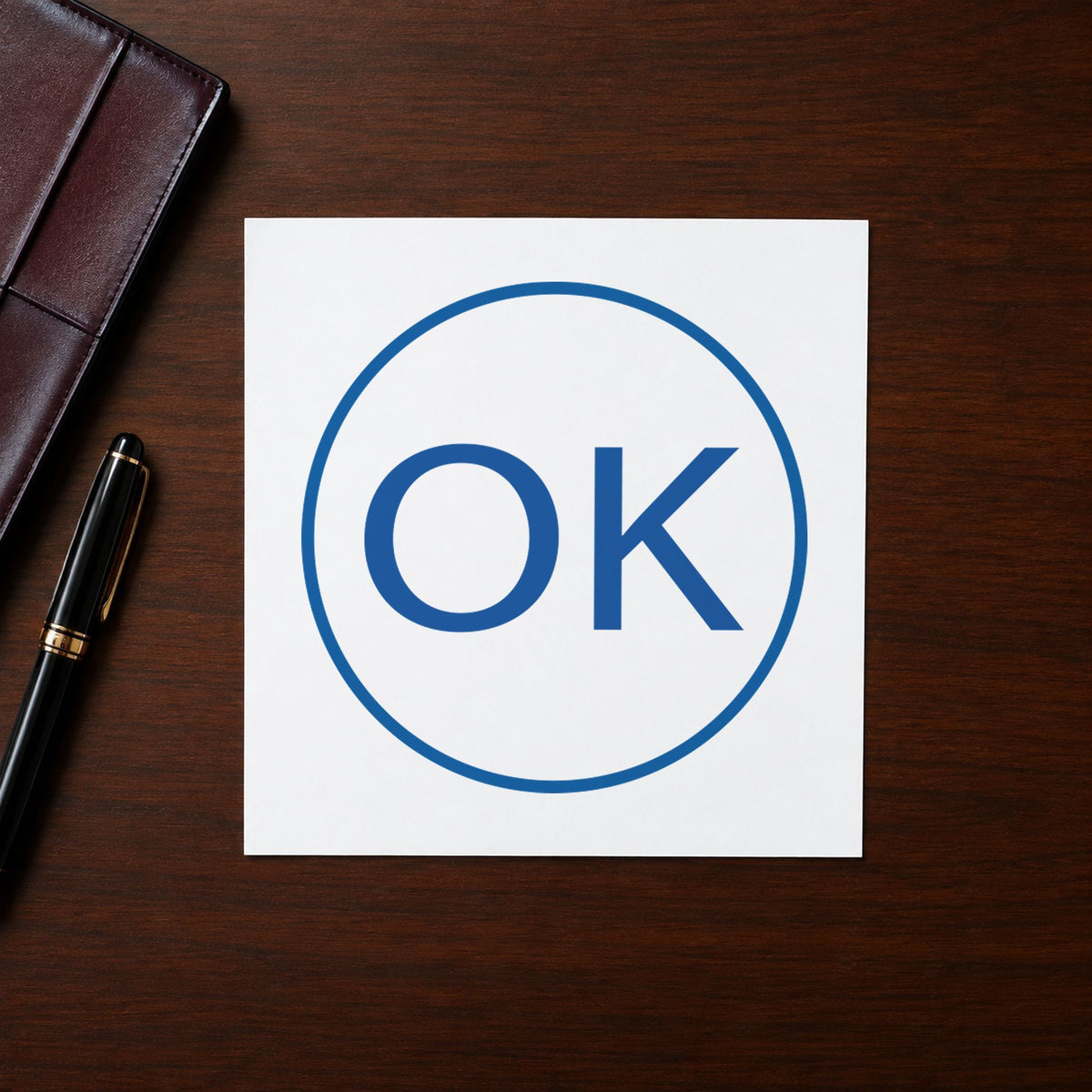 Pre-inked "OK" stamp marking paperwork in an office setting