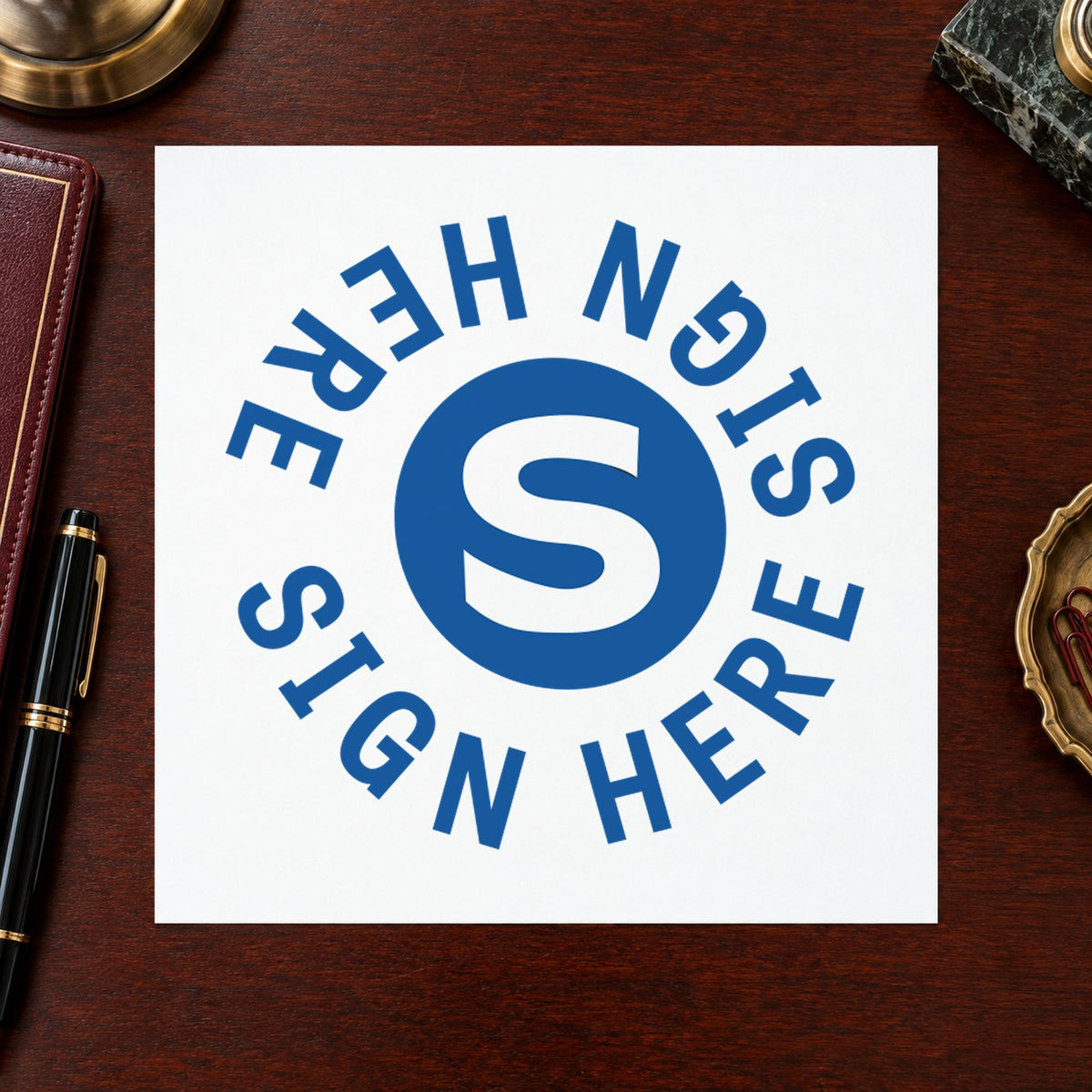 "Sign here" Xstamper pre-inked stamp beside its round imprint