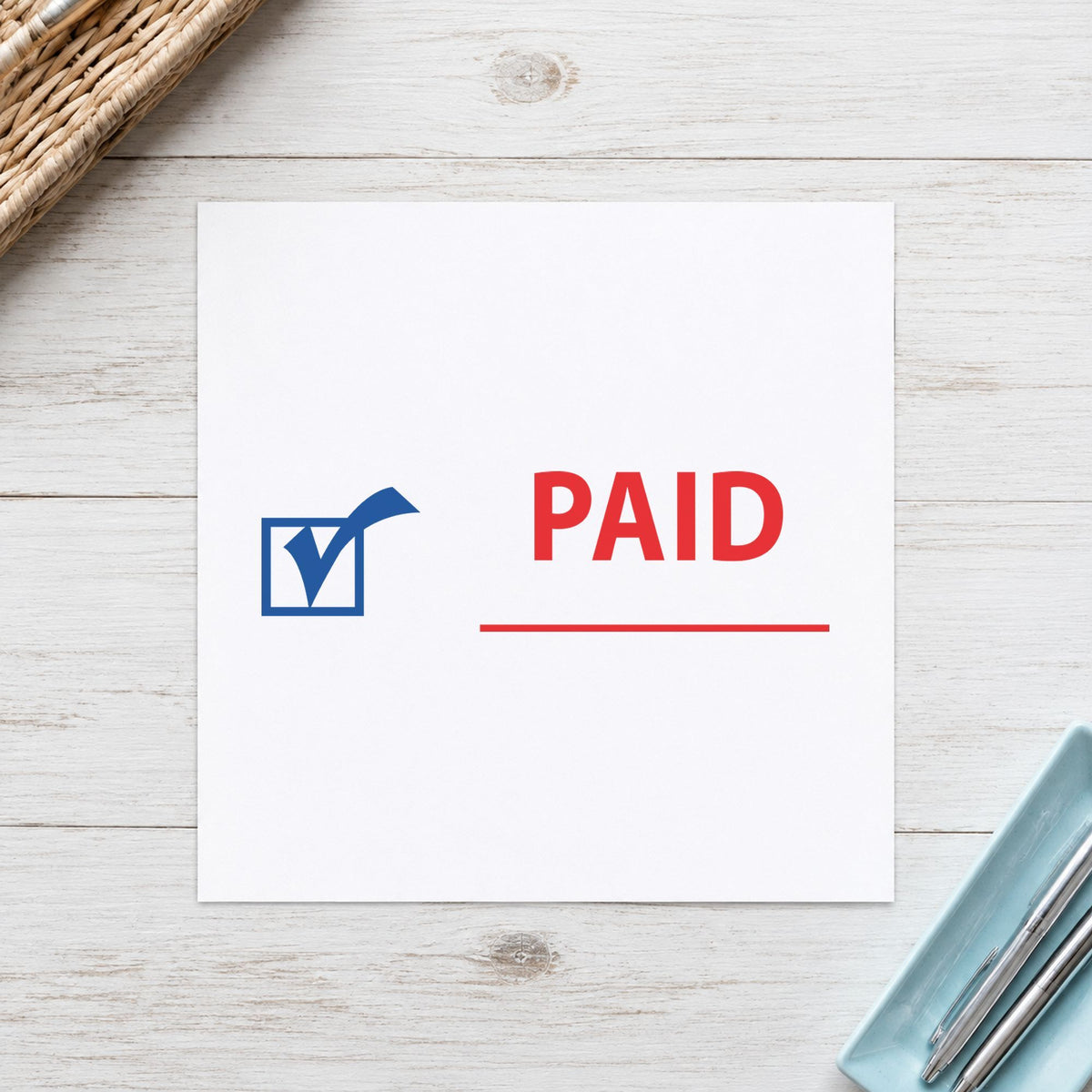 Pre-inked "Paid" stamp marking paperwork in an office setting