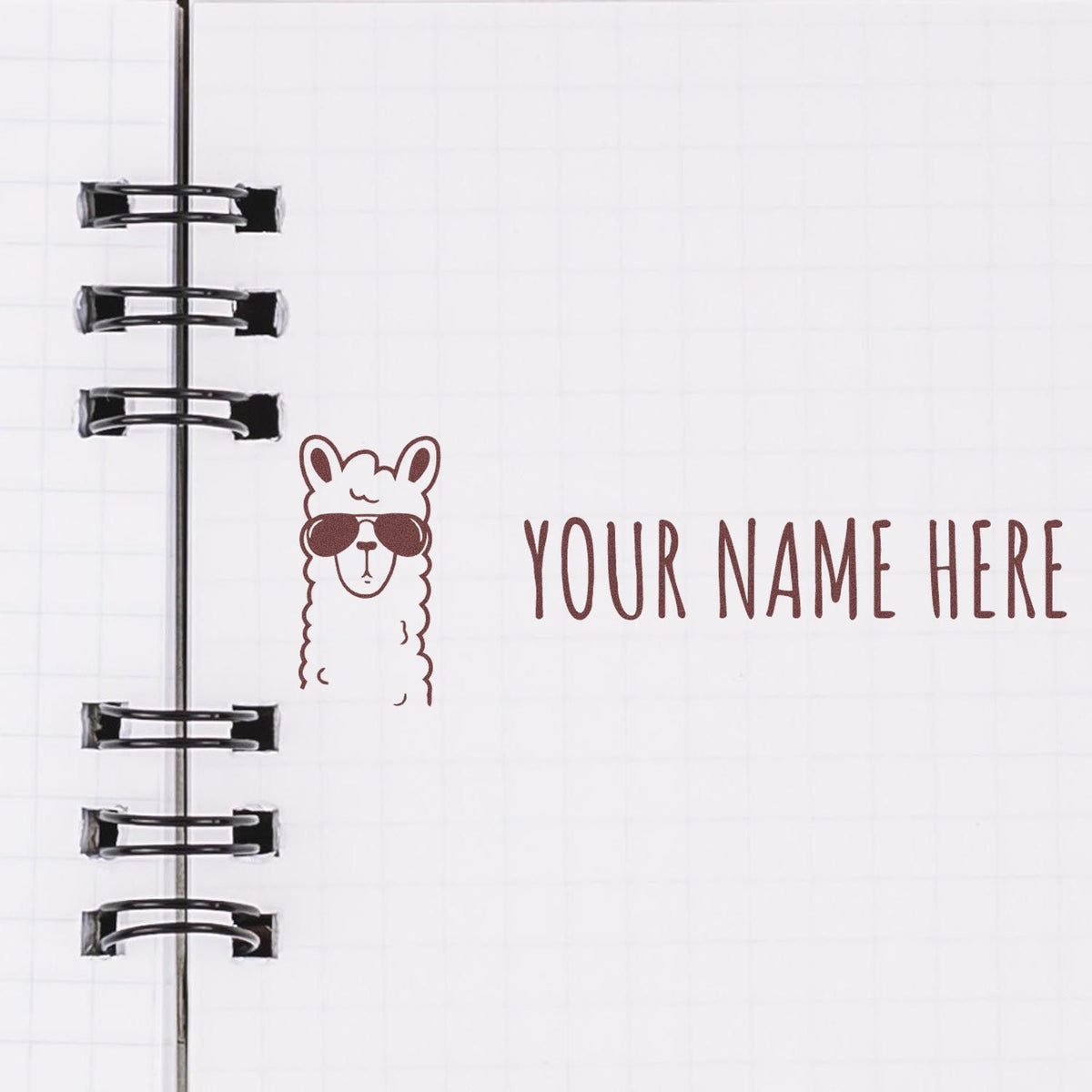 Custom stamp and seal with brown llama logo and YOUR NAME HERE on a white notebook page with black binder rings.