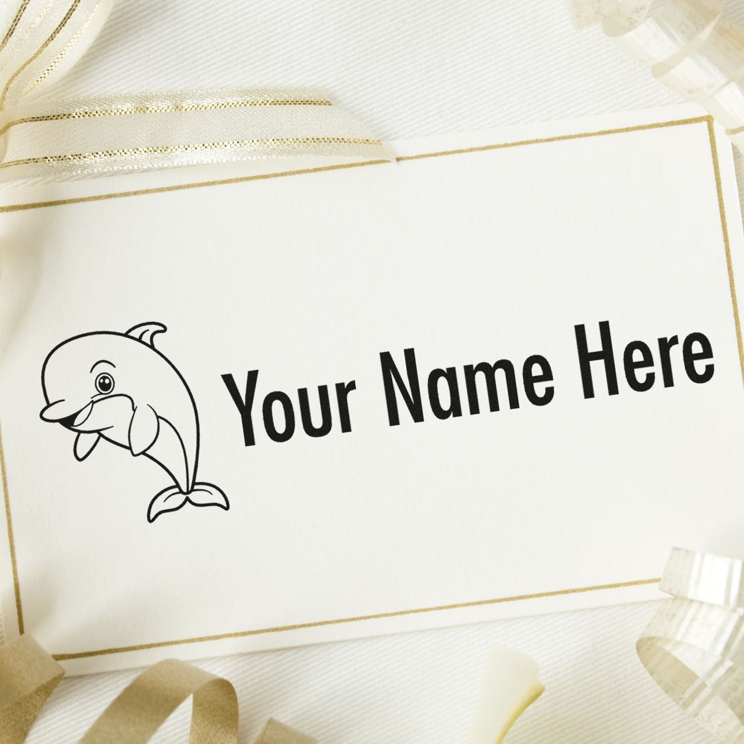 Custom stamp and seal card in white with black dolphin logo, bold Your Name Here text, and gold ribbon accents.