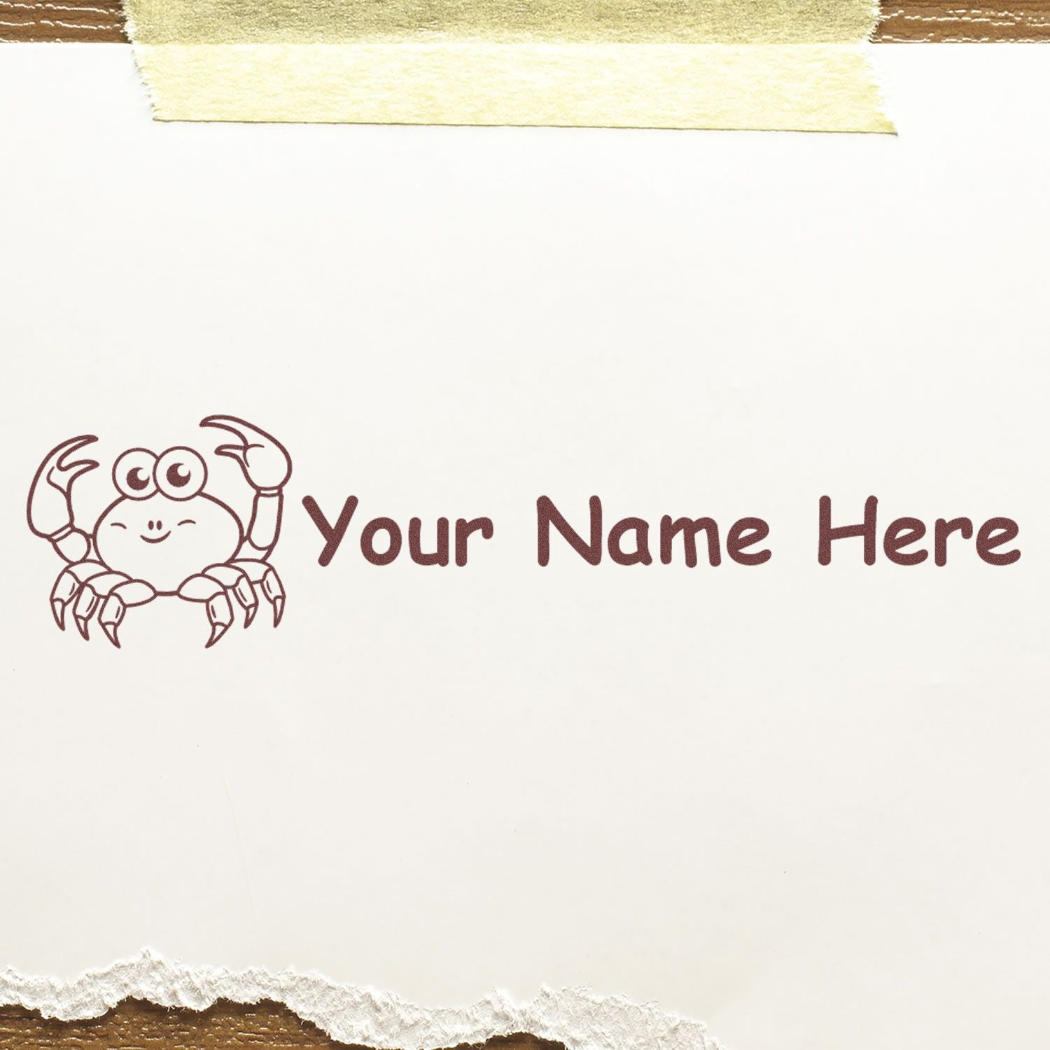 Brown crab custom stamp with Your Name Here on white paper, taped top and torn bottom edges