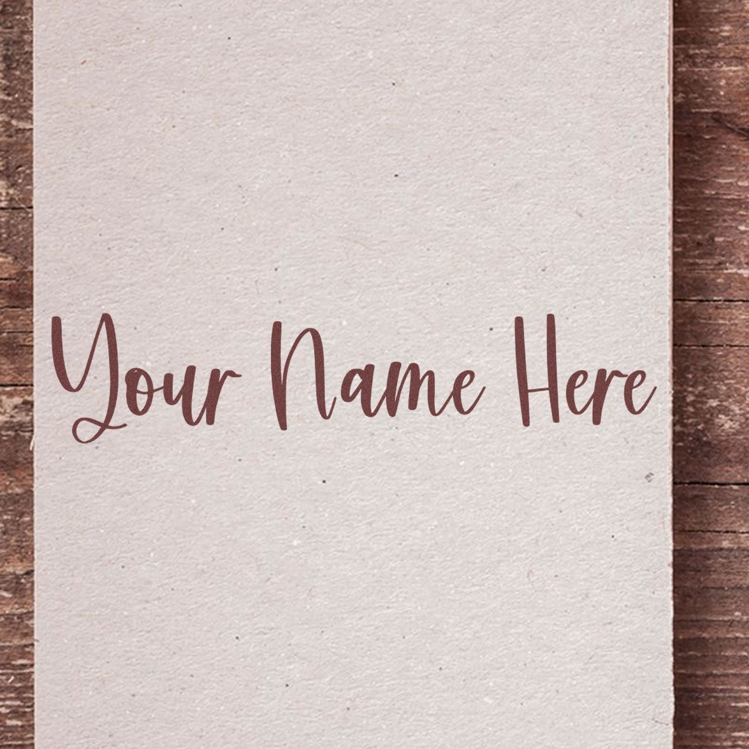 Cream custom stamp and seal card with brown script Your Name Here on a rustic wood background.