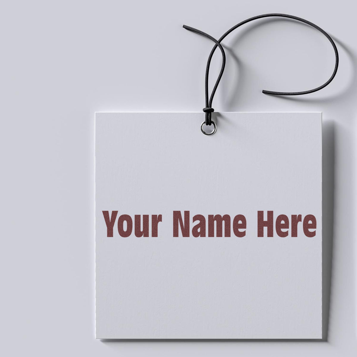 White custom stamp and seal tag with black cord, silver grommet, and burgundy Your Name Here text.