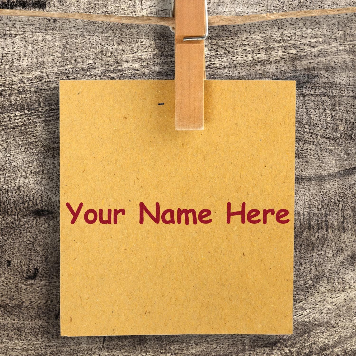 Custom stamp and seal on yellow kraft paper, clipped to wood, with red Your Name Here text.