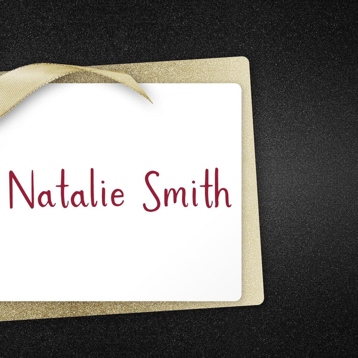 Custom stamp and seal card with maroon Natalie Smith on white, framed by gold glitter border and ribbon on black background.