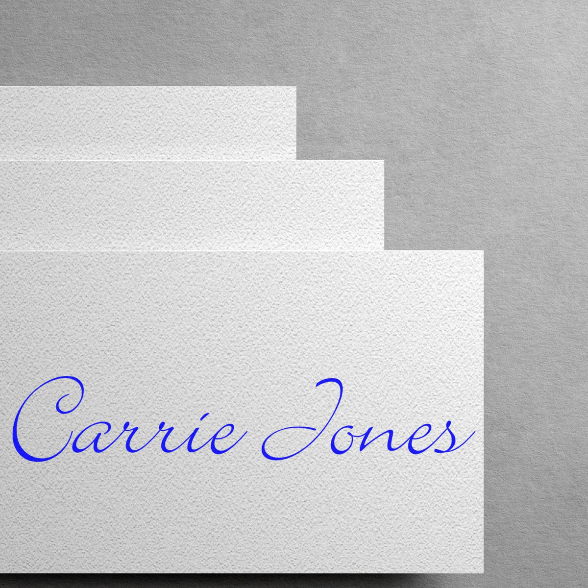Stacked white textured stamp and seal cards with blue cursive Carrie Jones on the front.